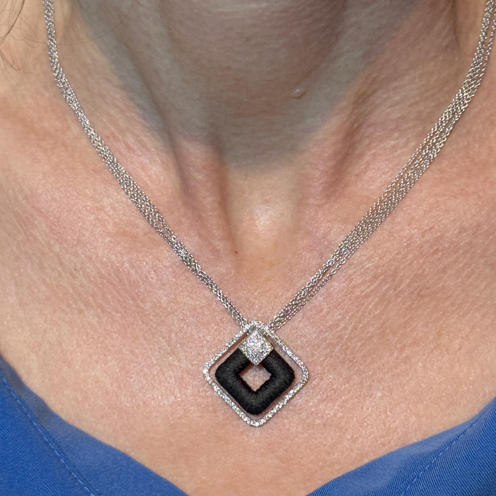 Ce superbe collier à pendentifs Yvel présente un design carré contemporain réalisé en or blanc et noir 18 carats. Le pendentif de 25 x 25 mm est encadré de 67 diamants ronds de taille brillant, totalisant environ 0,67 carats, de couleur G-H et de