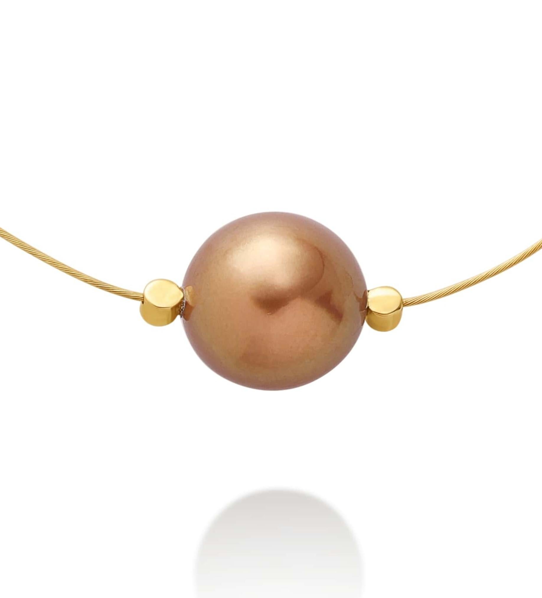 Le collier de perles de Tahiti brunes et dorées incarne l'élégance exotique de la Collection Slegma. Il est composé d'une seule perle de Tahiti brune et ronde de 11 à 12 mm de diamètre. Cette perle profonde, de couleur terre, sertie de 0,06 ct de