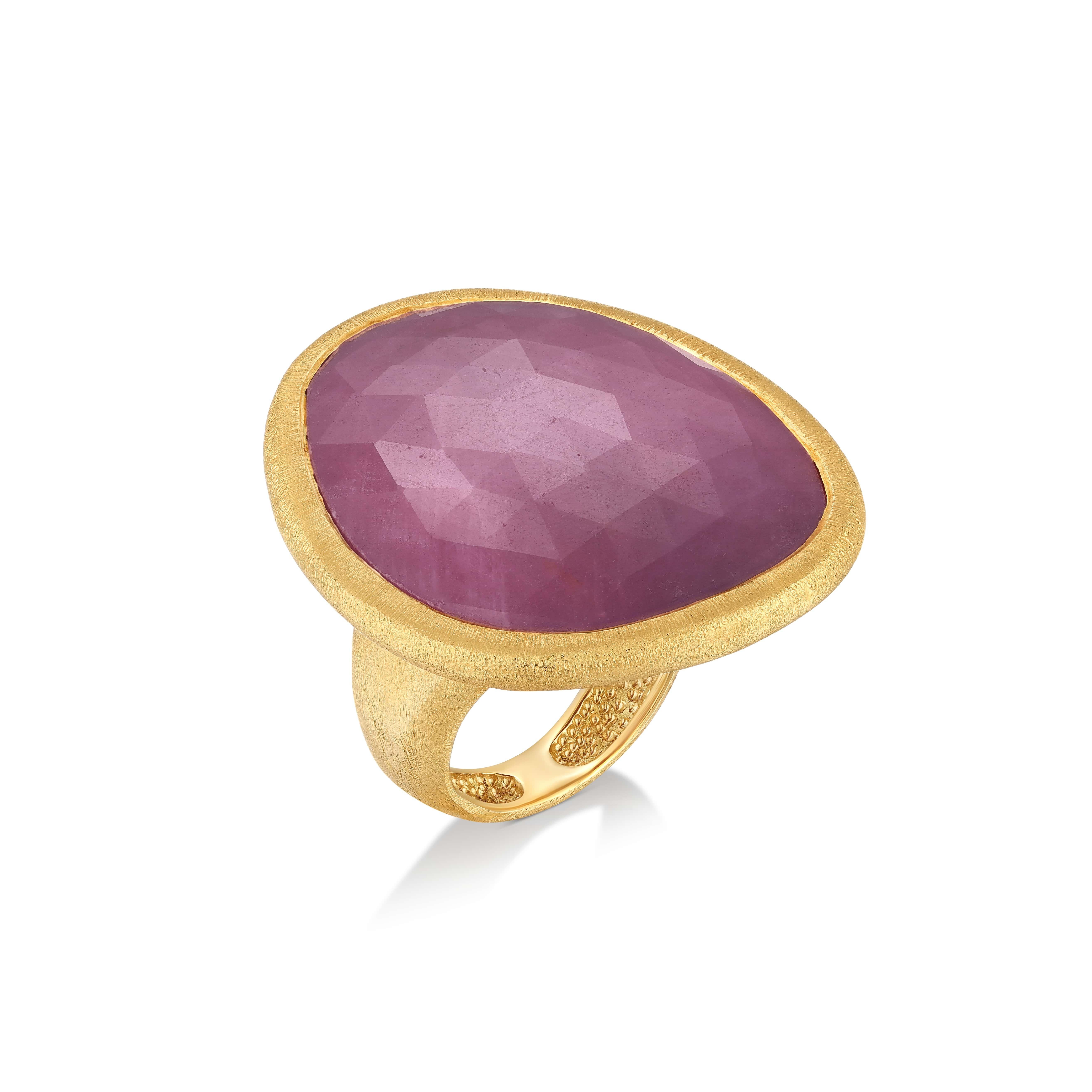 The Sapphire Ring from Yvel’s Rainbow Collection is a celebration of natural grandeur. This ring features a prominent 33.00 ct. natural sapphire, its faceted cut capturing the gem’s rich purple hue. The 18K yellow gold band, with a textured satin