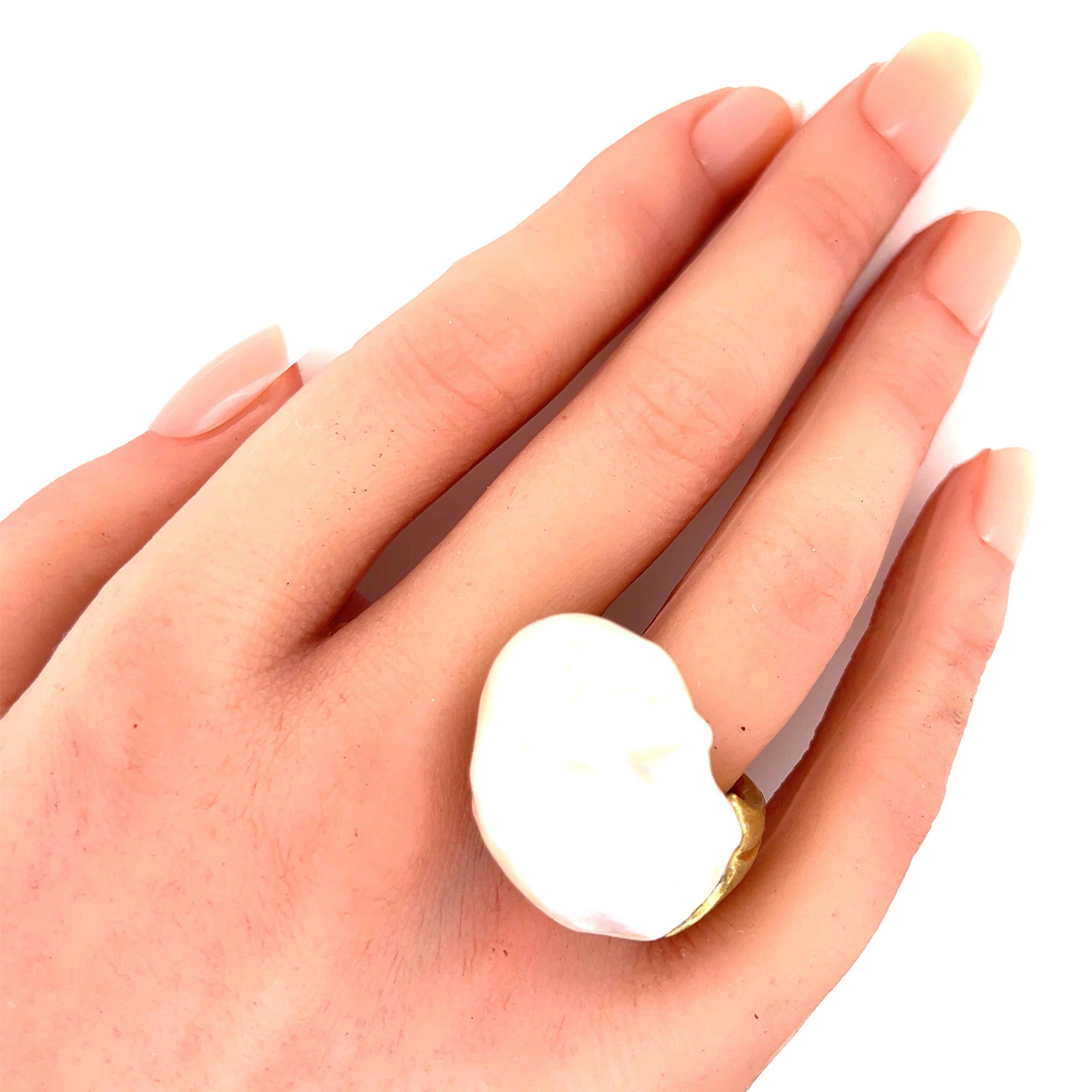 Autentico di Yvel, questo splendido anello è realizzato in oro giallo 18 carati; la parte superiore presenta una perla d'acqua dolce barocca satinata di forma curiosa attaccata alla parte superiore di ciascun gambo senza una cornice a ponte. Questo