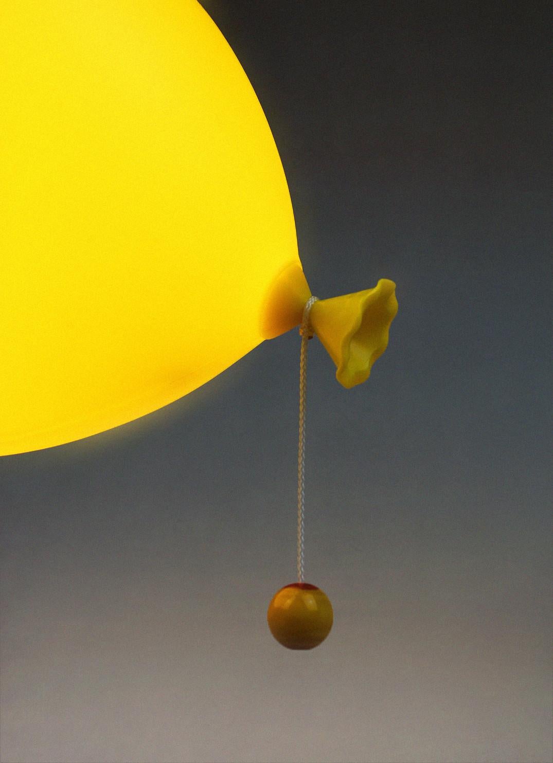 This wall, table or ceiling lamp was designed by Yves Christin for Bilumen in 1984. Because of its balloon shaped design, it is an icon on an international level. It is a yellow polypropylene lamp with black base that immediately stands out in your