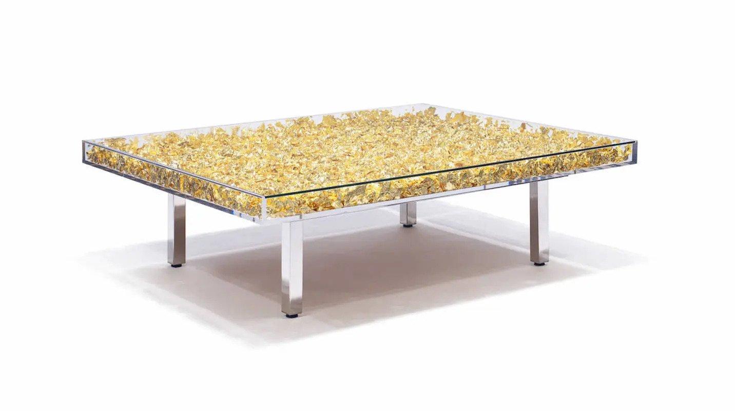 Mesa de centro diseñada por Yves Klein en 1961. Caja acrílica de cristal transparente rellena de 3000 láminas de pan de oro. La mesa se asienta sobre una estructura metálica con acabados y patas de metal pulido.