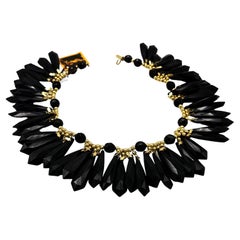 Yves Saint Lauren, prè-à-porter, 1980, gold metal,  jet-black resin tassel neck