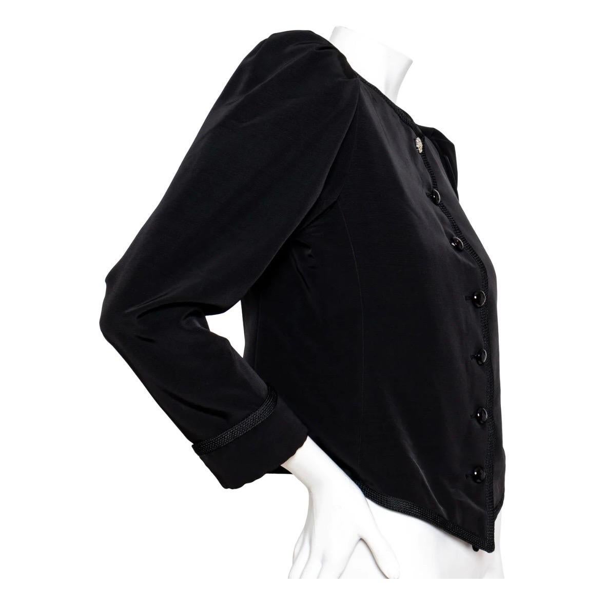 Puff Sleeve Jacket by Yves Saint Laurent Rive Gauche
Circa Late 1970s
Solid Black
Round neckline
Front closure with black faceted half circle buttons
Rhinestone flower button atop
Long puff sleeves with folded cuff
Pointed hemline in front
Signature