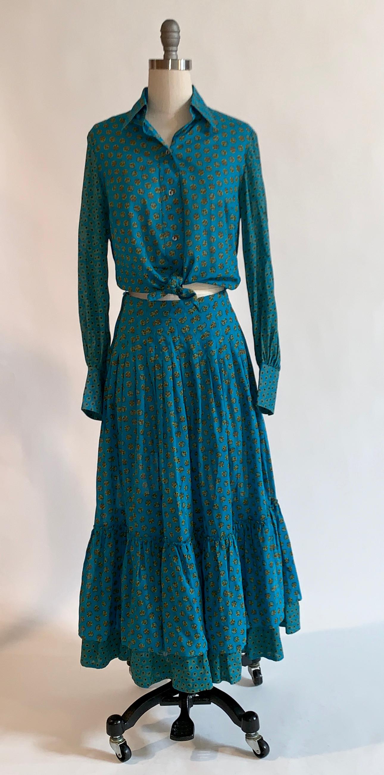 Vintage 1970s Yves Saint Laurent Rive Gauche blue print prairie style skirt with tiered ruffle hem and matching button up blouse. Fabric is slightly sheer. Collared blouse buttons at front and cuffs. Skirt fastens with side zip and hook.   

100%