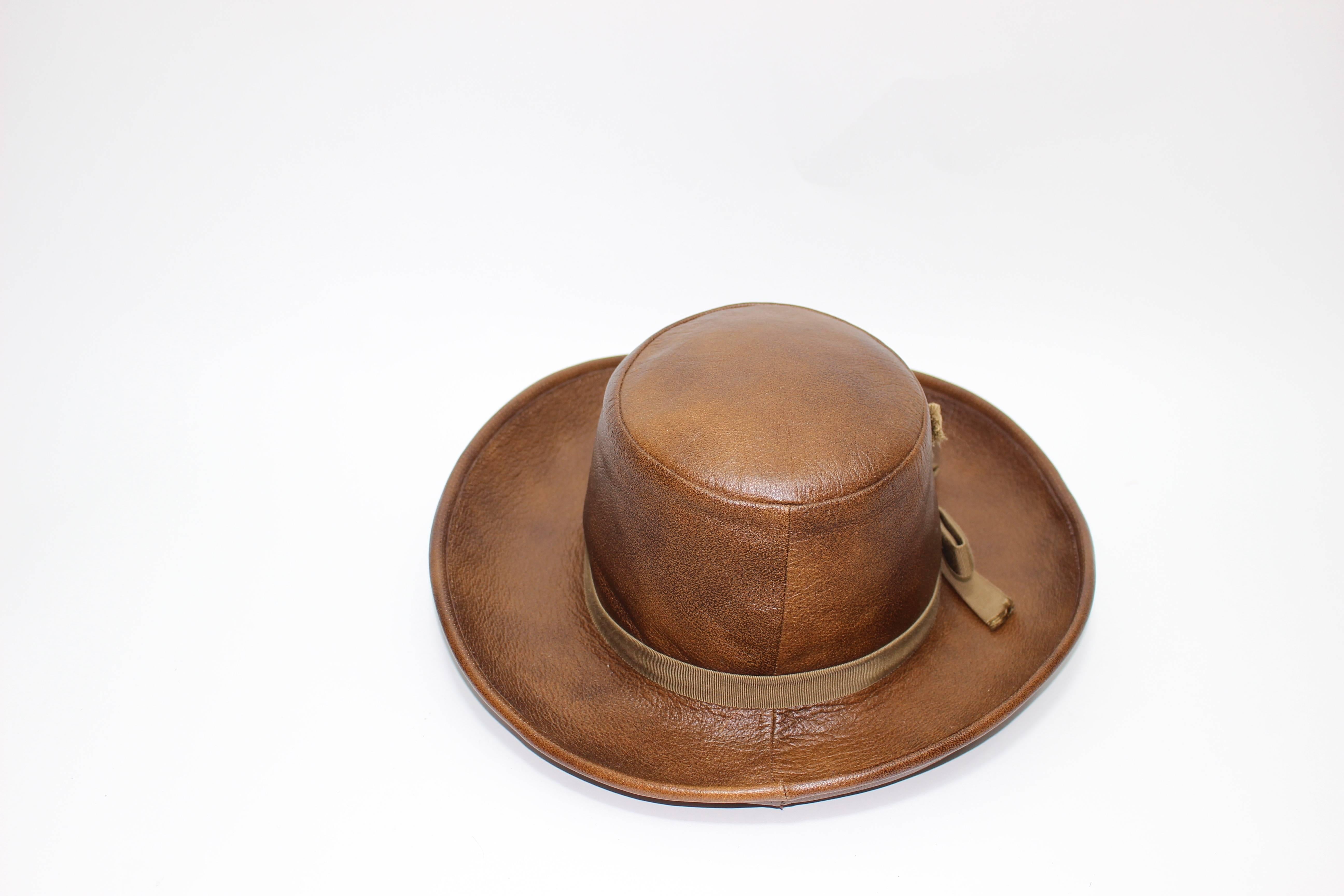 A brown leather Yves Saint Laurent hat.
Excellent condition

Measurements:
Brim: 3 and 1/4 inches 
Crown height: 4 inches
Inner circumference: 21.5 inches