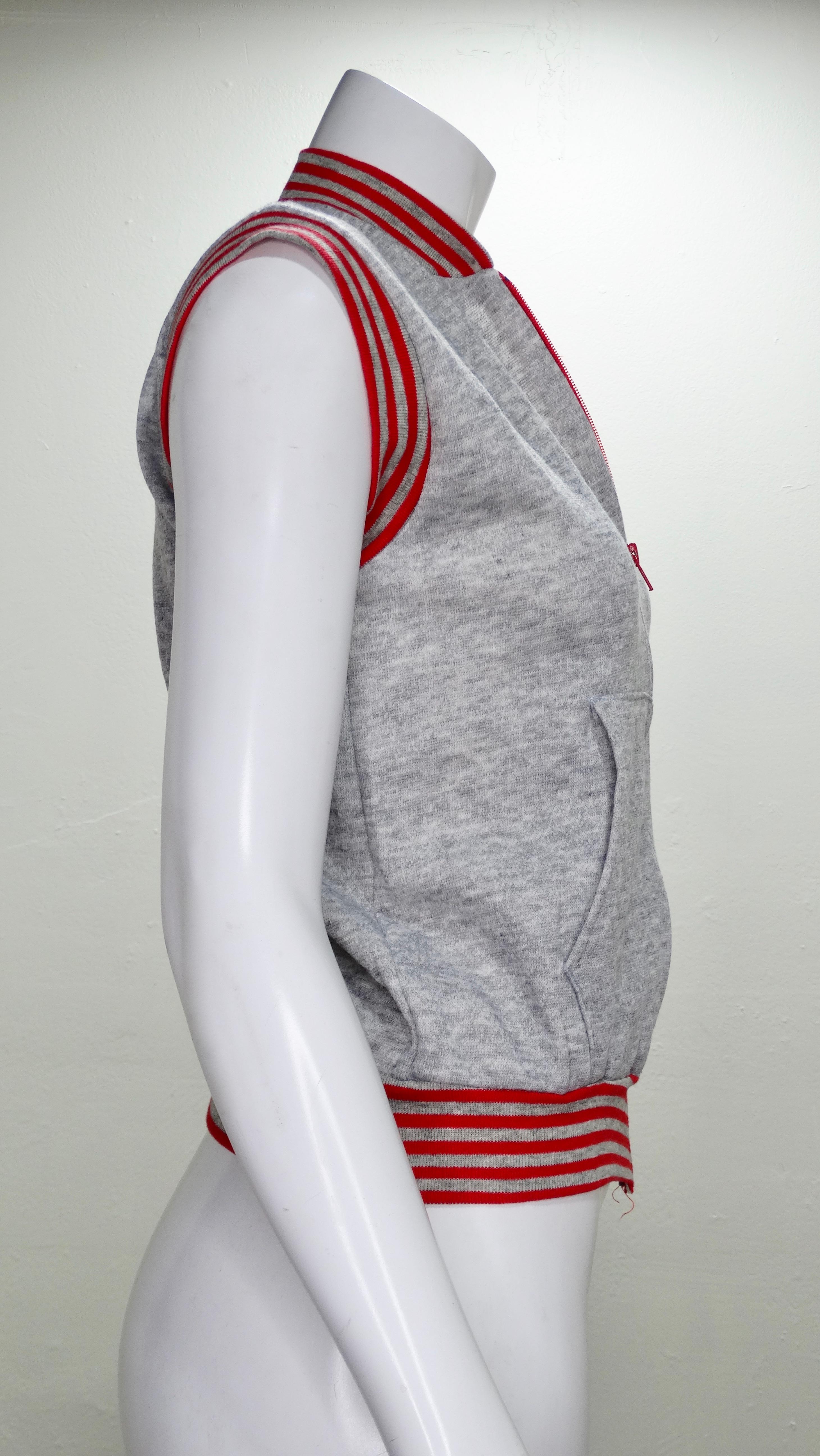 Nobody does it quite like Yves Saint Laurent! Circa early 1970s, this grey vest from YSL's activewear line features a grey and red striped hem, YSL logo on the front, two front pockets and a red zipper closure. Original tag intact, marked a size M