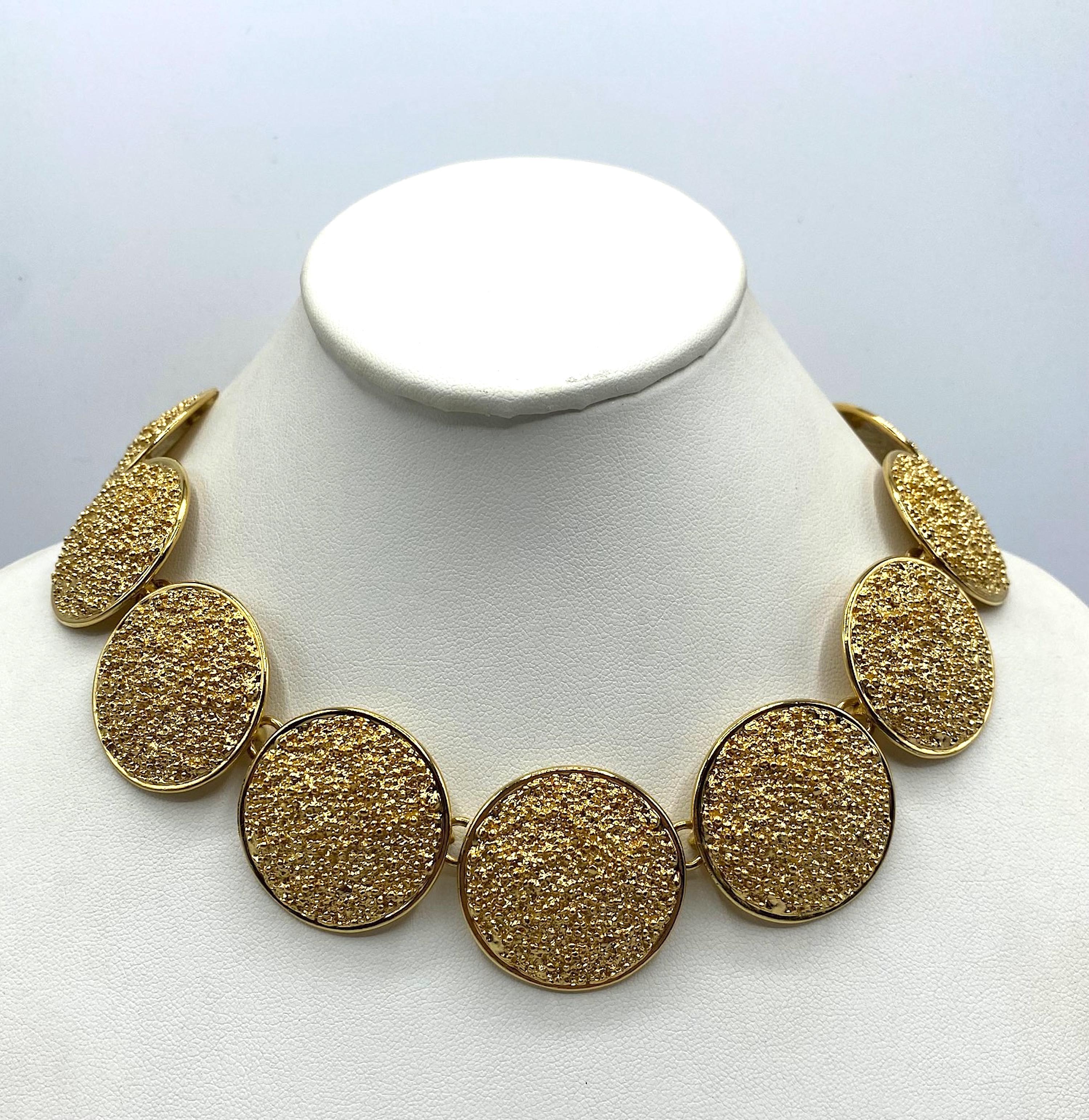 Presented is an impressive vintage Yves Saint Laurent necklace from the mid 1980s to early 1990s. It is comprised of 11 lightly domed disk links measuring 1.25 inches in diameter and  having a rough gold nugget texture. The necklace is 19.25 inches