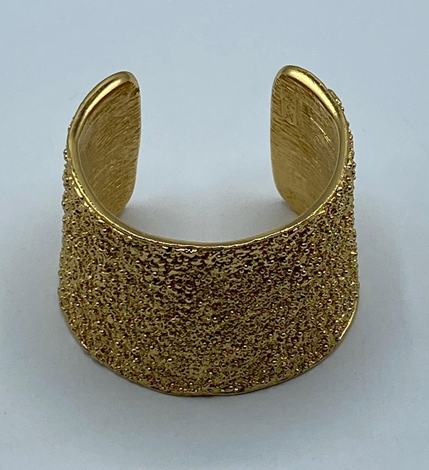 Presented is an impressive vintage Yves Saint Laurent cuff bracelet from the mid 1980s to early 1990s. The shape is lightly oval and tapers from 2.75 inches at the top widest points to 2.38 at the bottom. The hight of the cuff is a substantial 2.13