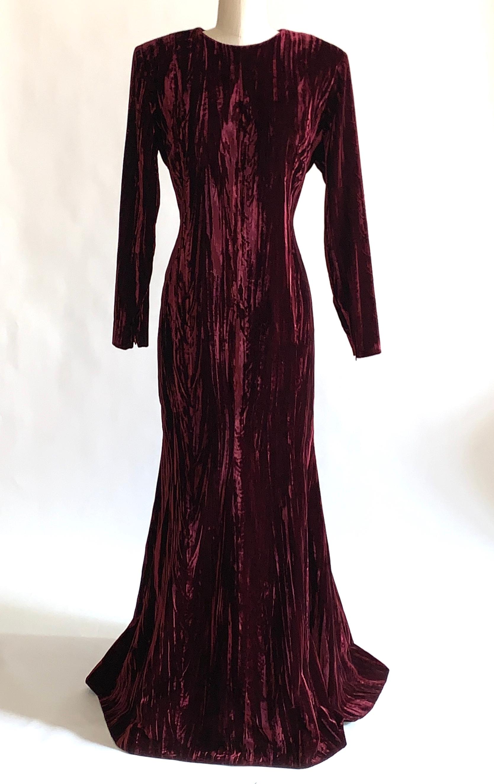 Vintage Yves Saint Laurent Rive Gauche burgundy velvet dress, circa 1980s/90s. Textured velvet with a sort of moire pattern. Long sleeve, fitted through the body with a slight flare at skirt. Padding at shoulders. Zippers at wrist ensure a tailored