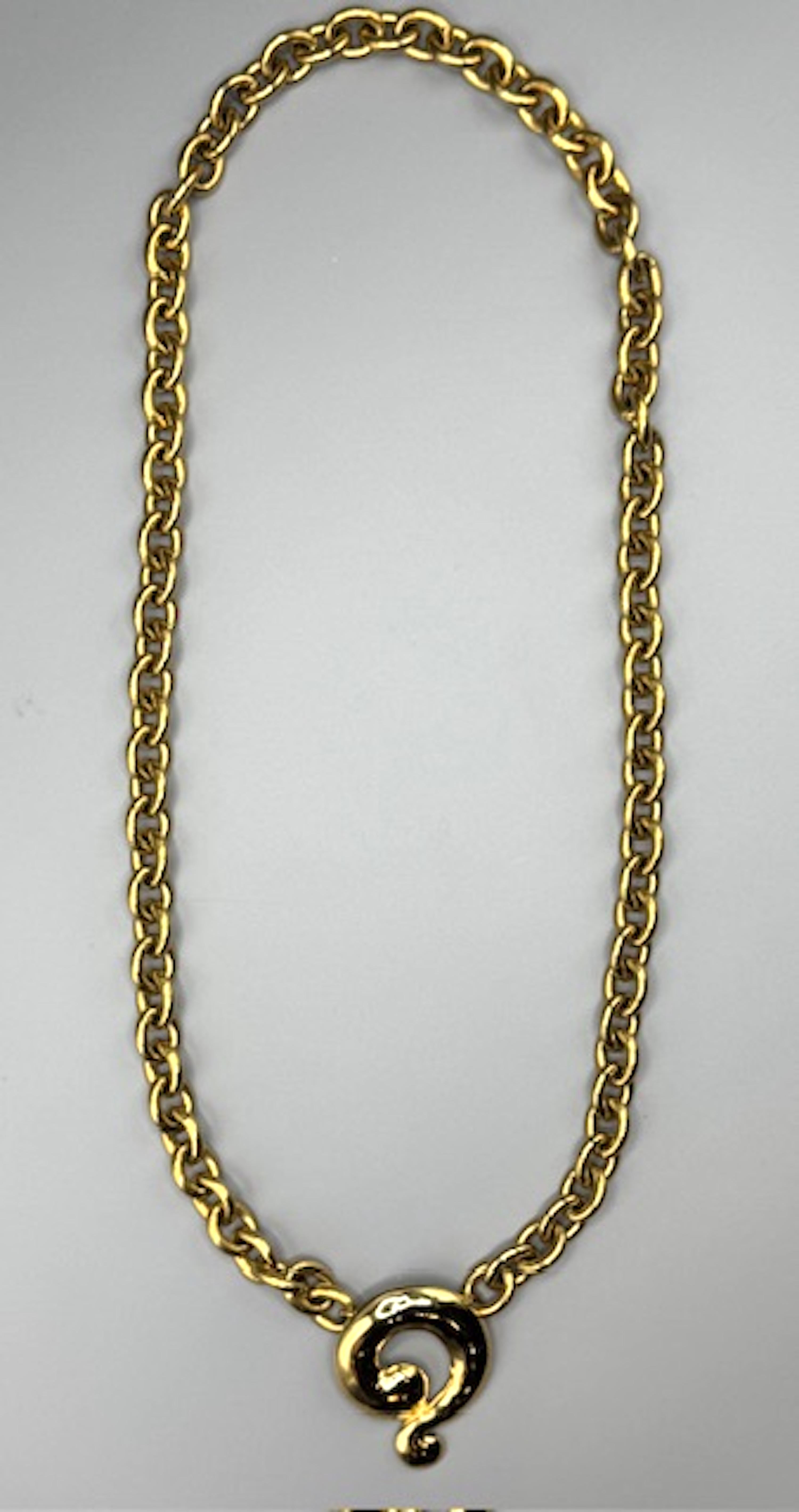 Questa collana con ciondolo di Yves Saint Laurent, risalente agli anni '80, incarna un'eleganza senza tempo e un design audace, caratteristici dell'estetica di YSL. Realizzato in una ricca lastra d'oro, presenta una sostanziosa catena a maglie che