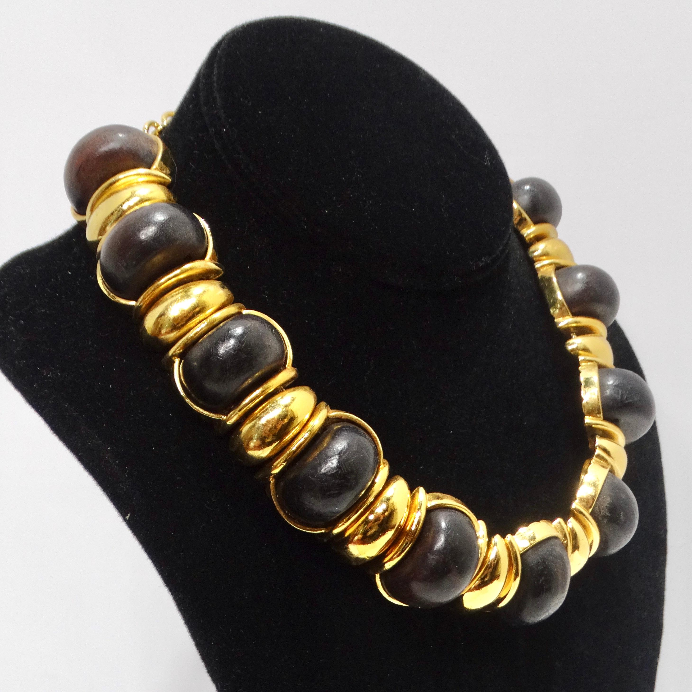 Do not miss out on a necklace that's not just an accessory but a fashion statement - the Yves Saint Laurent 1980s Gold Tone Wood Choker Necklace. This vintage choker necklace combines exotic black wood with bold gold tone metal links to create a