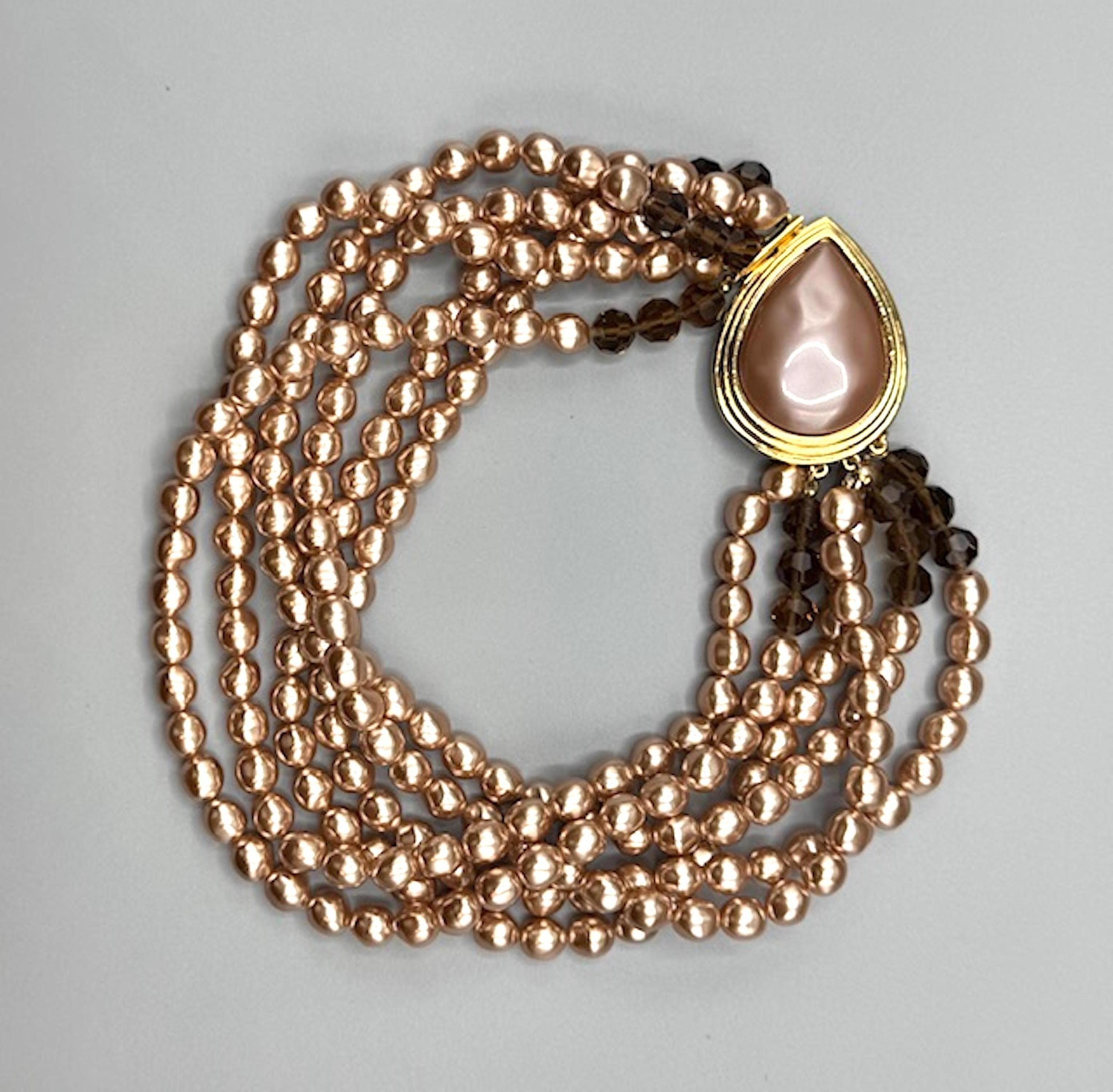 La collana a sei fili di perle finte barocche di Yves Saint Laurent degli anni '80 è un pezzo di lusso e senza tempo. Ecco una panoramica delle sue caratteristiche principali:
	-	Design/One: Sei fili di perle finte barocche color blush intervallate