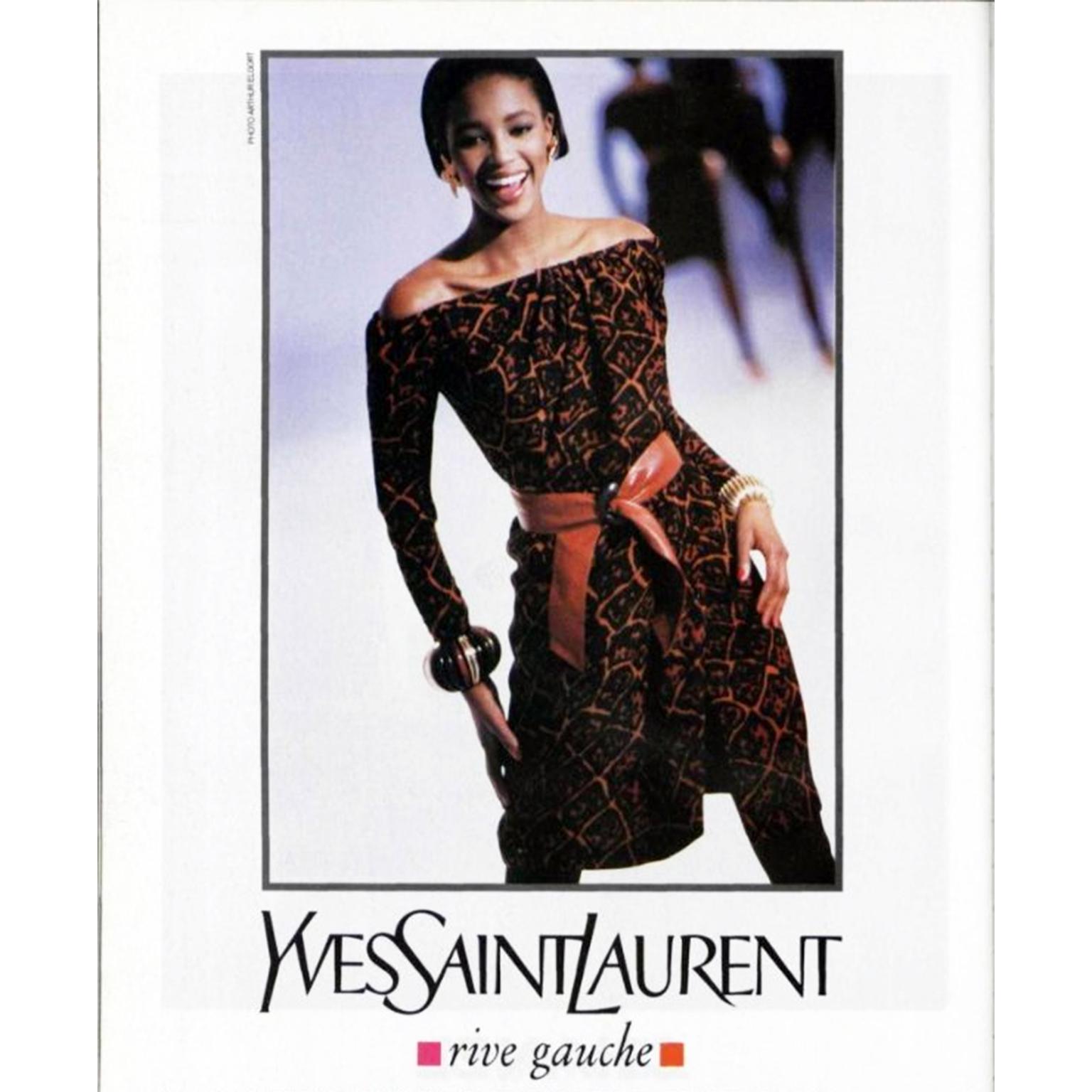 This 1980 vintage Yves Saint Laurent off shoulder dress is in an abstract brown and orange silk animal print. This dress was featured on both the YSL runway and in a Rive Gauche print ad campaign. The dress is shown with the tawny brown leather belt