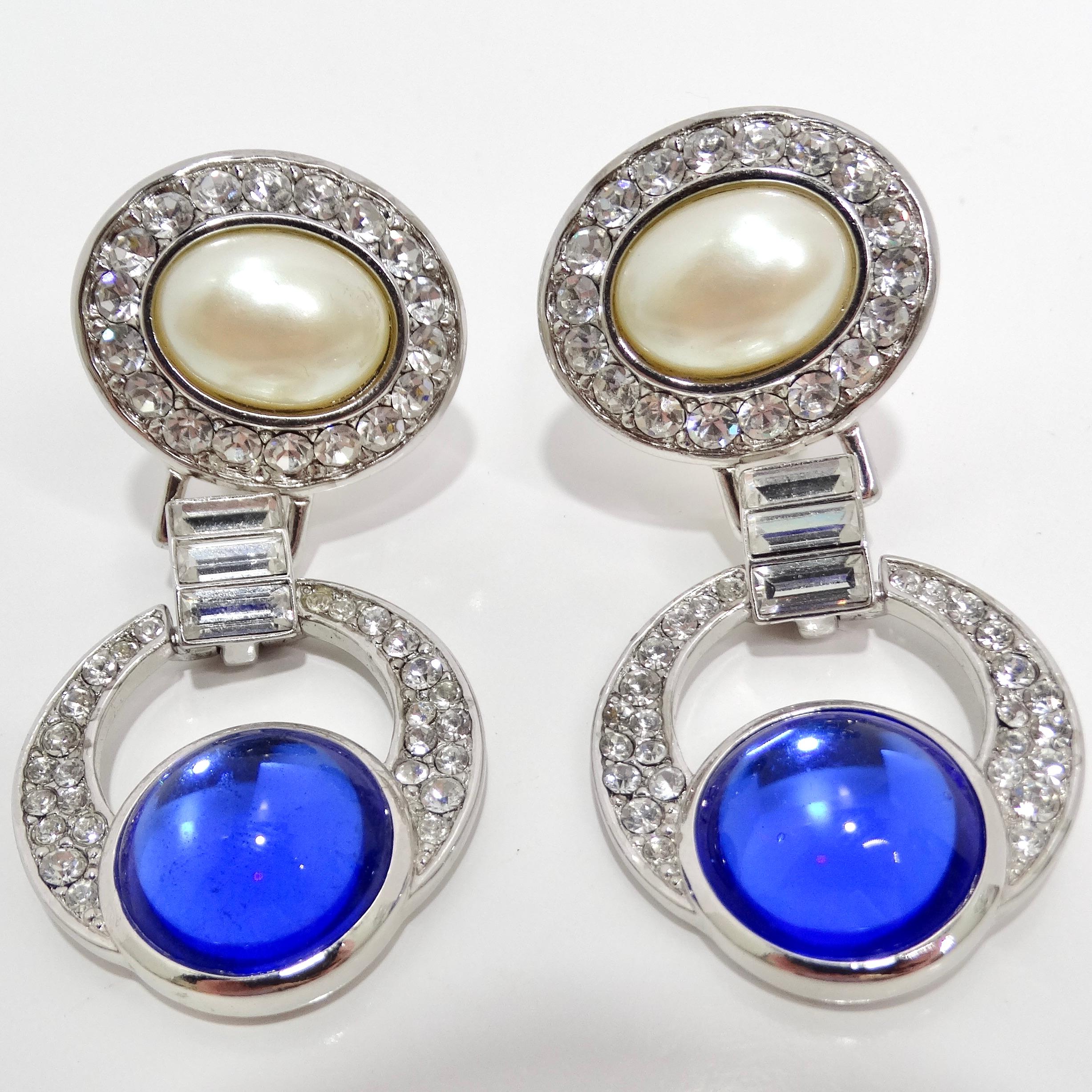 Wir präsentieren die Yves Saint Laurent 1990s Faux Sapphire Pearl Dangle Earrings, ein glamouröses und fesselndes Design, das die Opulenz und Raffinesse dieser Zeit verkörpert. Diese exquisiten Ohrringe zeichnen sich durch eine mehrdimensionale