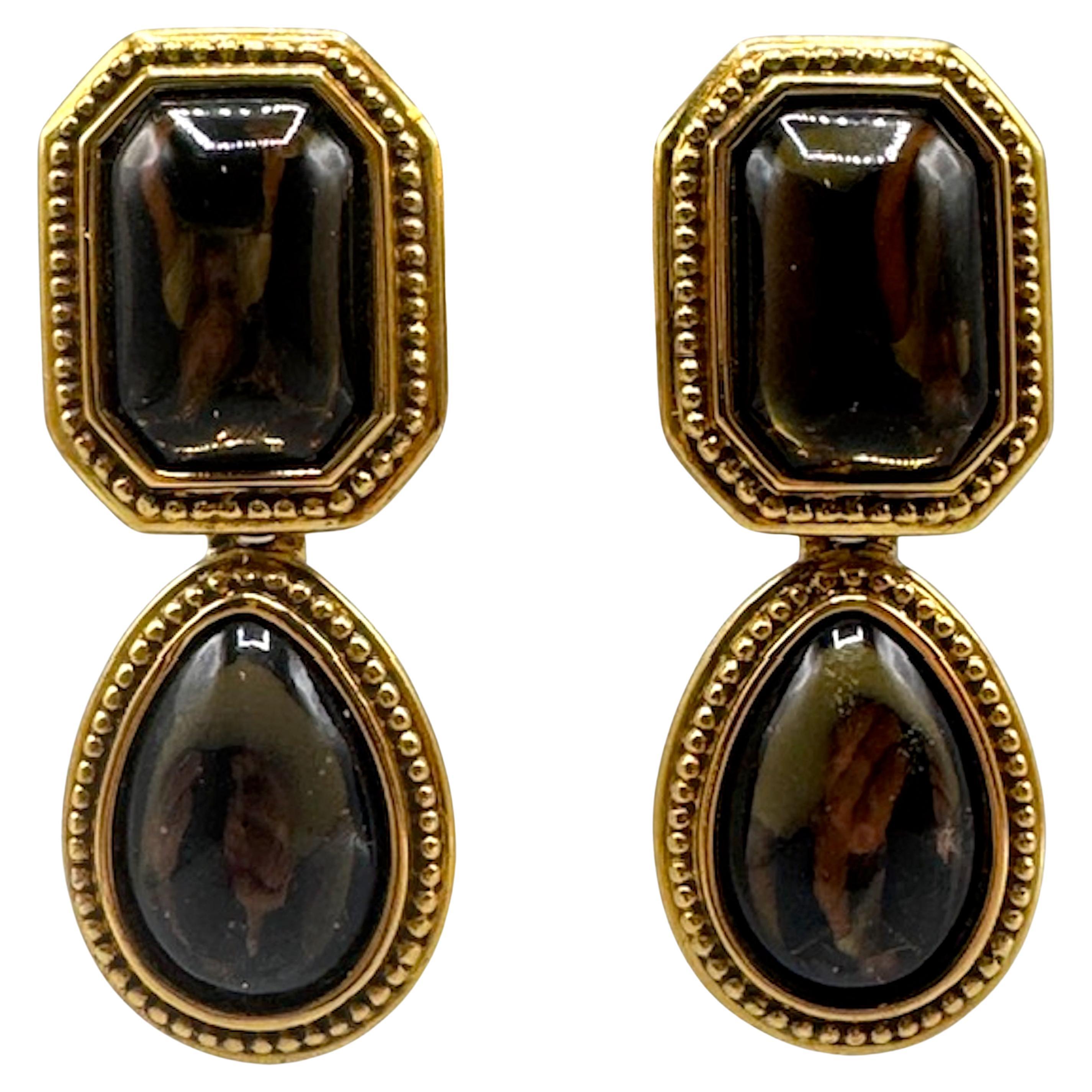 A classic and statement making pair of 1980s to 1990s  Yves Saint Laurent Byzantine Revival earrings! The combination of gold-tone metal, emerald and amber-colored cabochons, and intricate beadwork is very characteristic of YSL’s bold, opulent