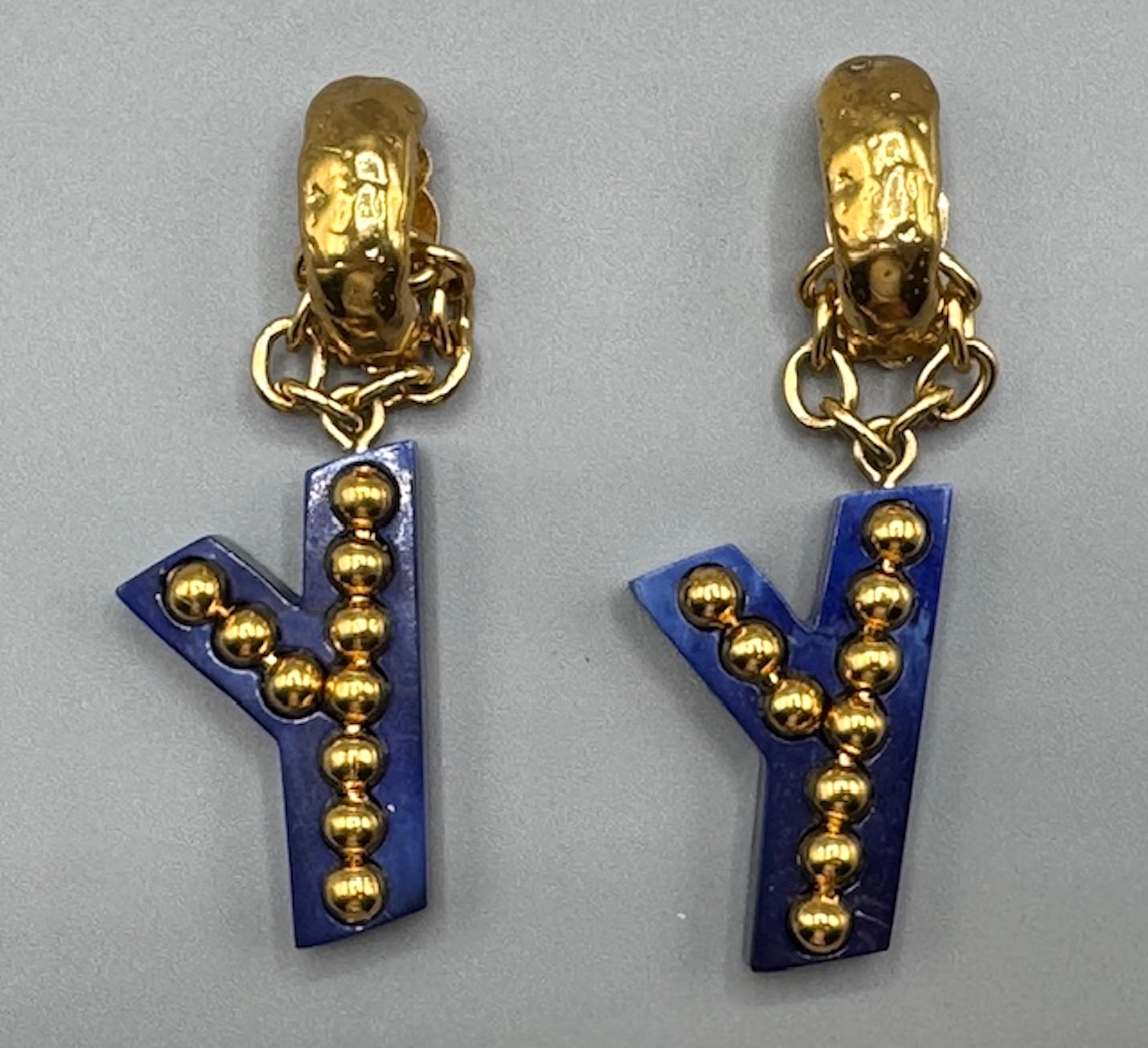 These Yves Saint Laurent 1990s gold and blue “Y” letter pendant earrings are a great example of the logo-centric fashion trend of the decade. The mix of gold-plated metal with the martele' texture and the rich royal-to-navy blue resin pendants gives