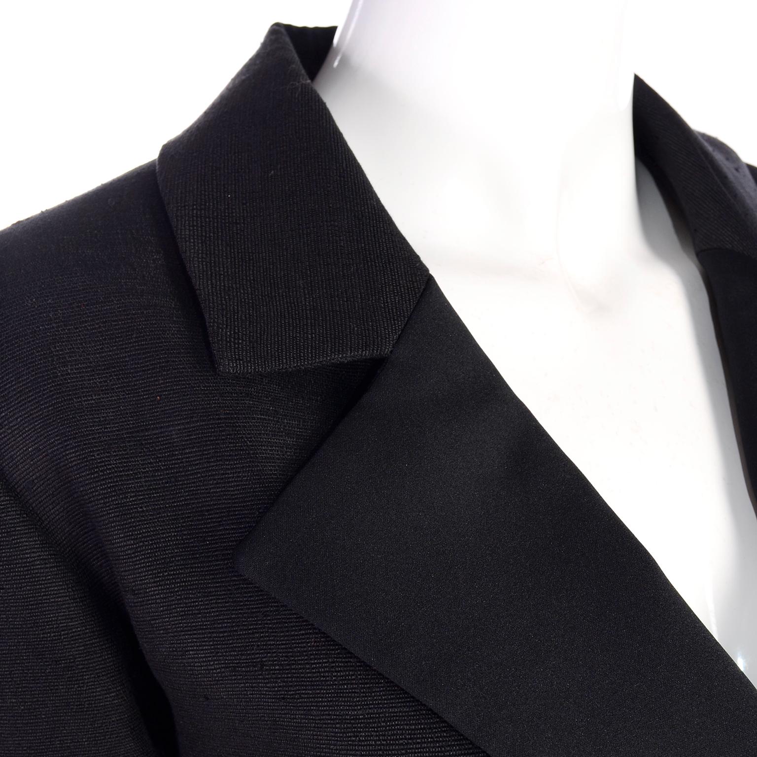 Yves Saint Laurent Rive Gauche black skirt suit that looks like raw silk. The blazer jacket is double breasted with textured large black buttons. The skirt has nice pleats in front, with a front pleated over slit. The lower lapel on the jacket is a