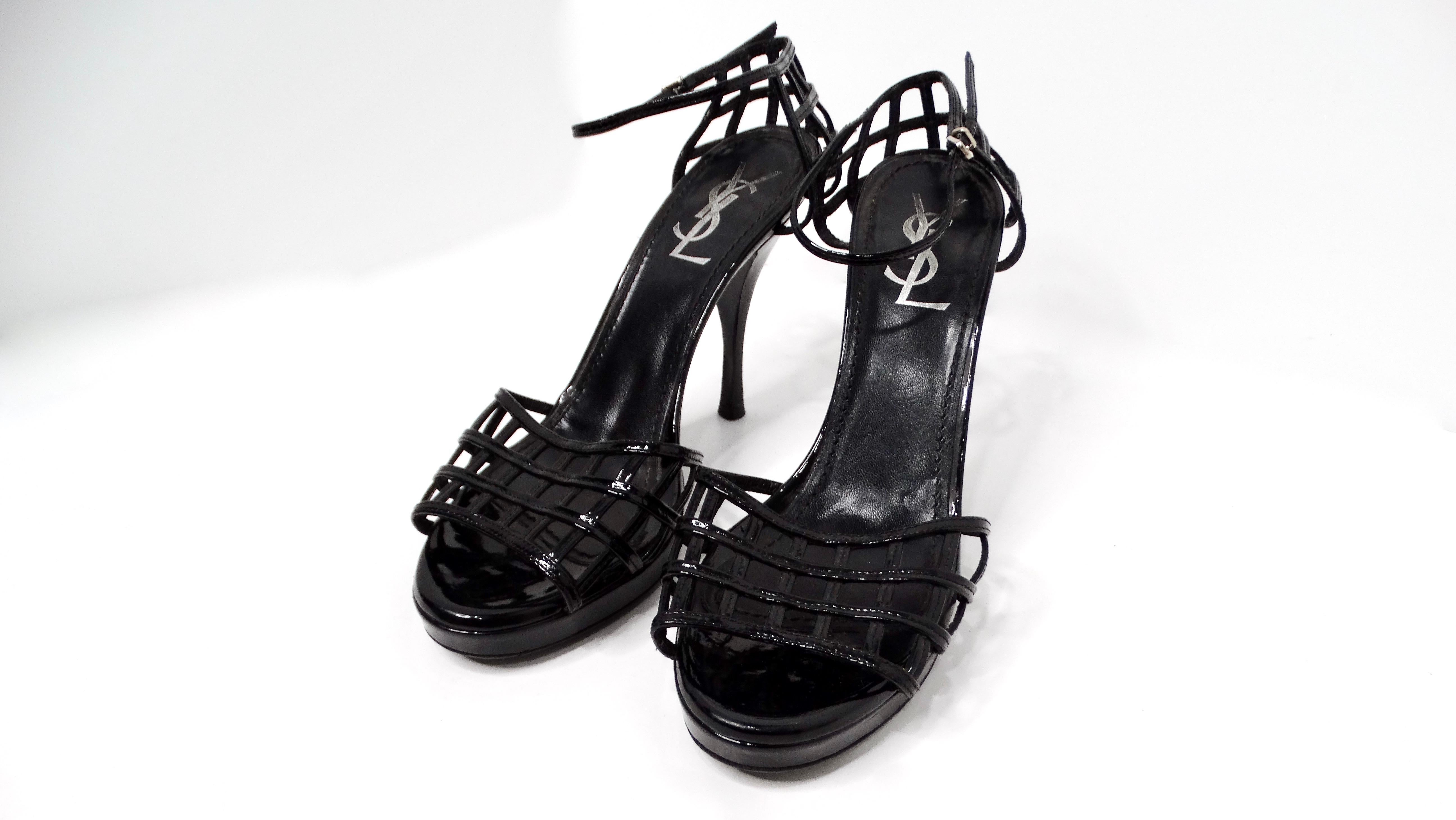 The Yves Saint Laurent 2009 Black Patent Leather Cage Sandal Heels are a stunning embodiment of chic sophistication and daring design. Crafted from black patent leather, these heels feature an eye-catching cage-style toe strap that artfully