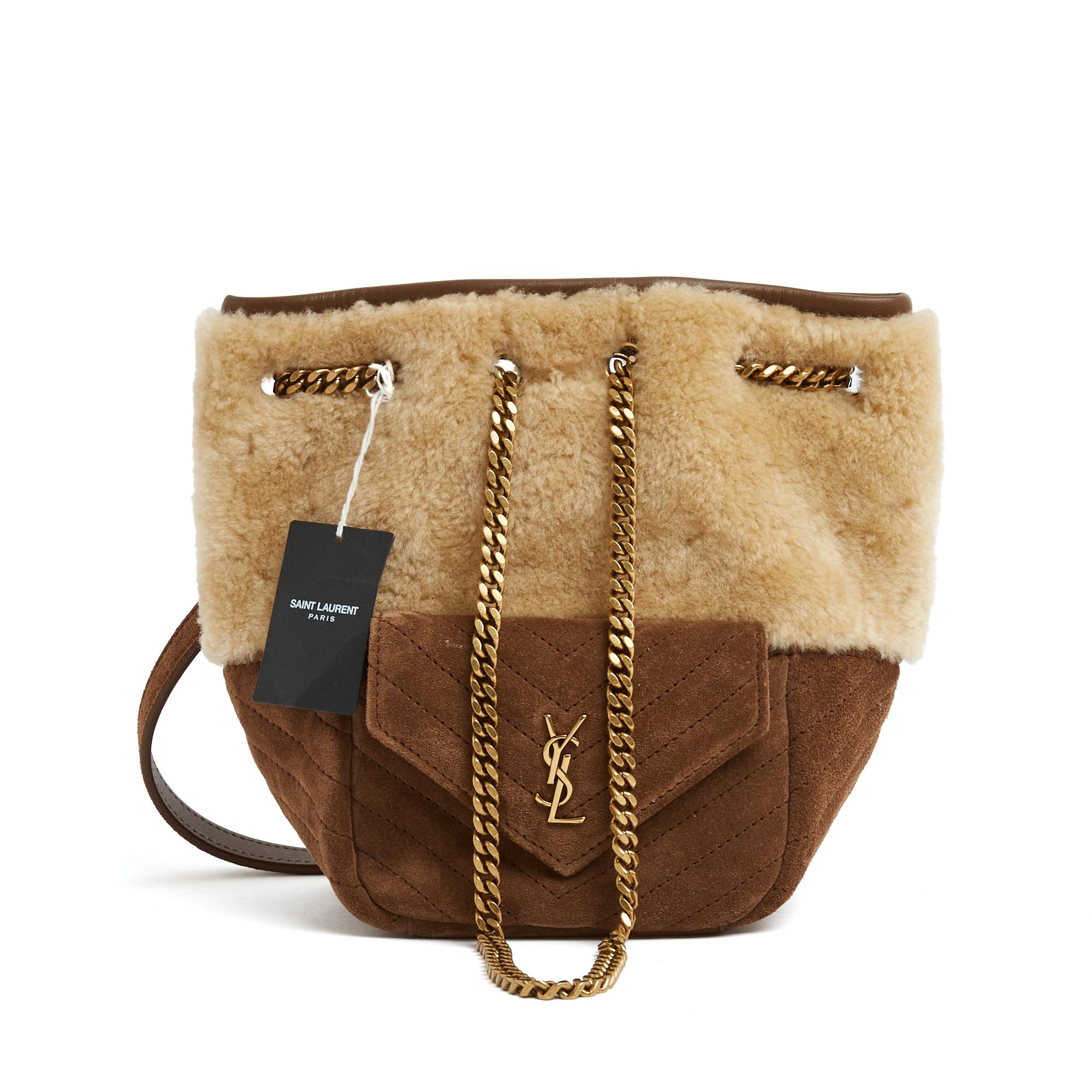 Saint Laurent Mini Joe Bucket Bag aus beigem Shearling und Wildleder, eine Mini-Tasche auf der Vorderseite mit dem YSL-Logo aus altgoldenem Metall verziert, Innenausstattung aus ecrufarbenem Canvas, Schulterriemen aus Leder und Kette. Breite 13 cm x