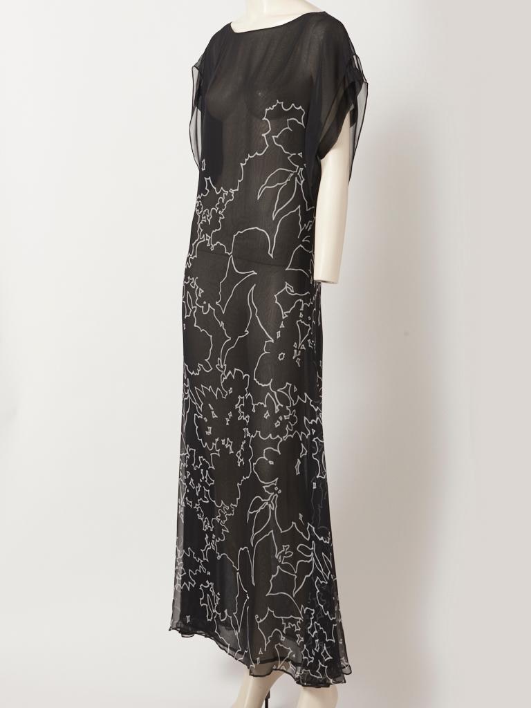 Yves Saint Laurent, Rive Gauche, gentle, flowing capped sleeve, black background, with a white abstract print, double layered, chiffon, chemise style long dress, having a boat neckline. Dress simply slips over the head combining a certain ease with 