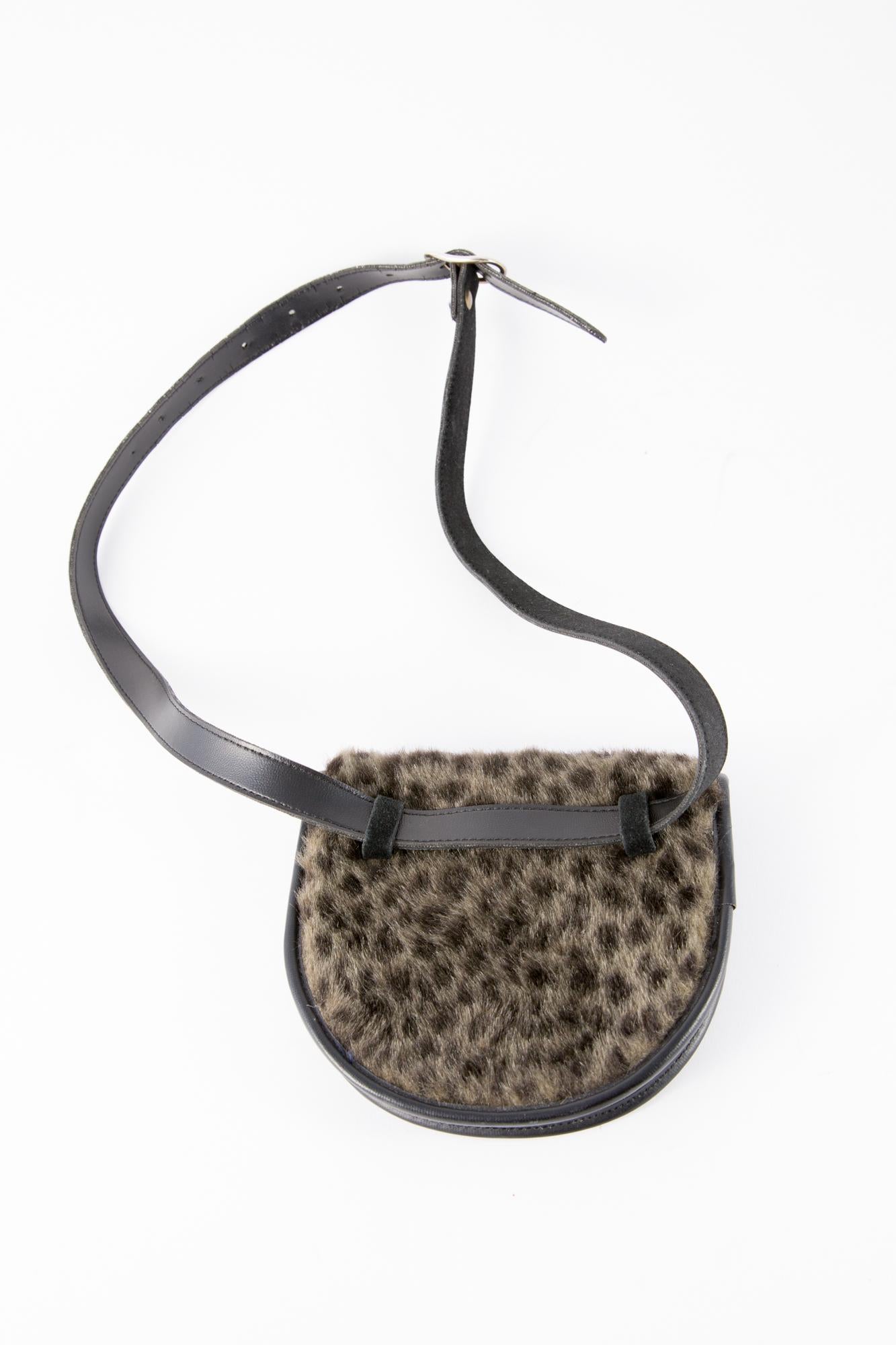 1990s, Yves Saint Laurent black leather and fake animal print fur belt bag featuring an adjustable suede leather belt with a silver tone buckle, as  is meant to be worn around the waist. It gets also a front snap under front flap and an an internal