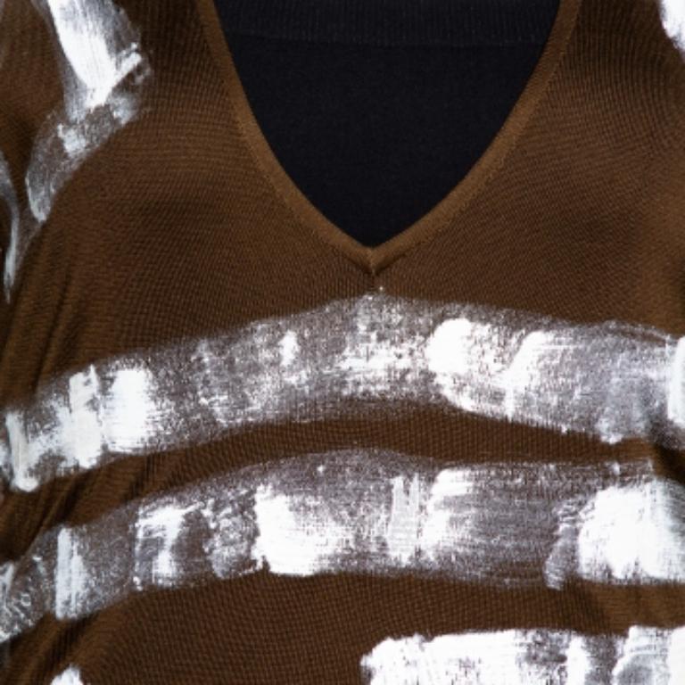 This top from Yves Saint Laurent is an example of an intricate design. The prime quality fabric used in this army green top and the paint detailing make it stand out. This top from the Spring 2002 Ready to Wear collection offers a V-neck and long