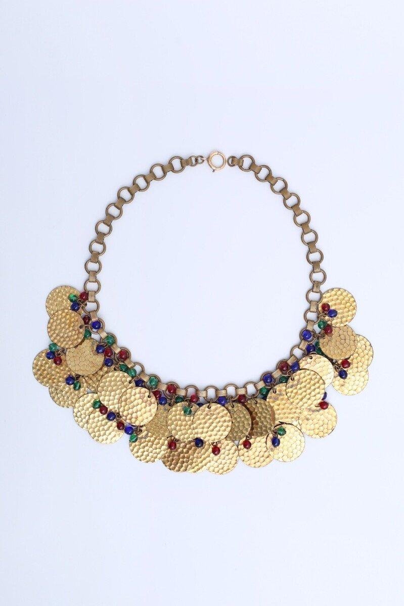 Yves Saint Laurent (Attribuito a) Set di collana e bracciale composto da piccoli pendenti in metallo dorato martellato e perline multicolore su una catena. Nessuna firma, risale agli anni '60.

Condizioni:
Buone condizioni generali. Un po' di patina