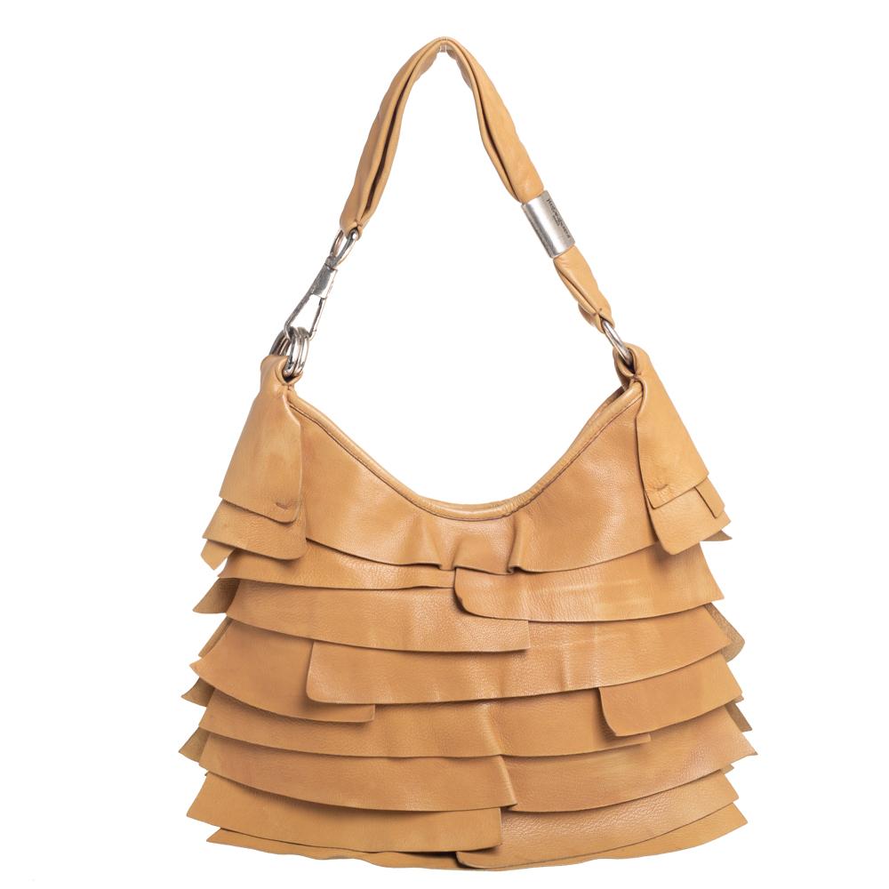 The St. Tropez hobo by Yves Saint Laurent is a unique creation that will instantly charm you. It is crafted from leather in a beige shade and styled with ruffles on the exterior. It has a spacious suede interior that can easily carry all your daily