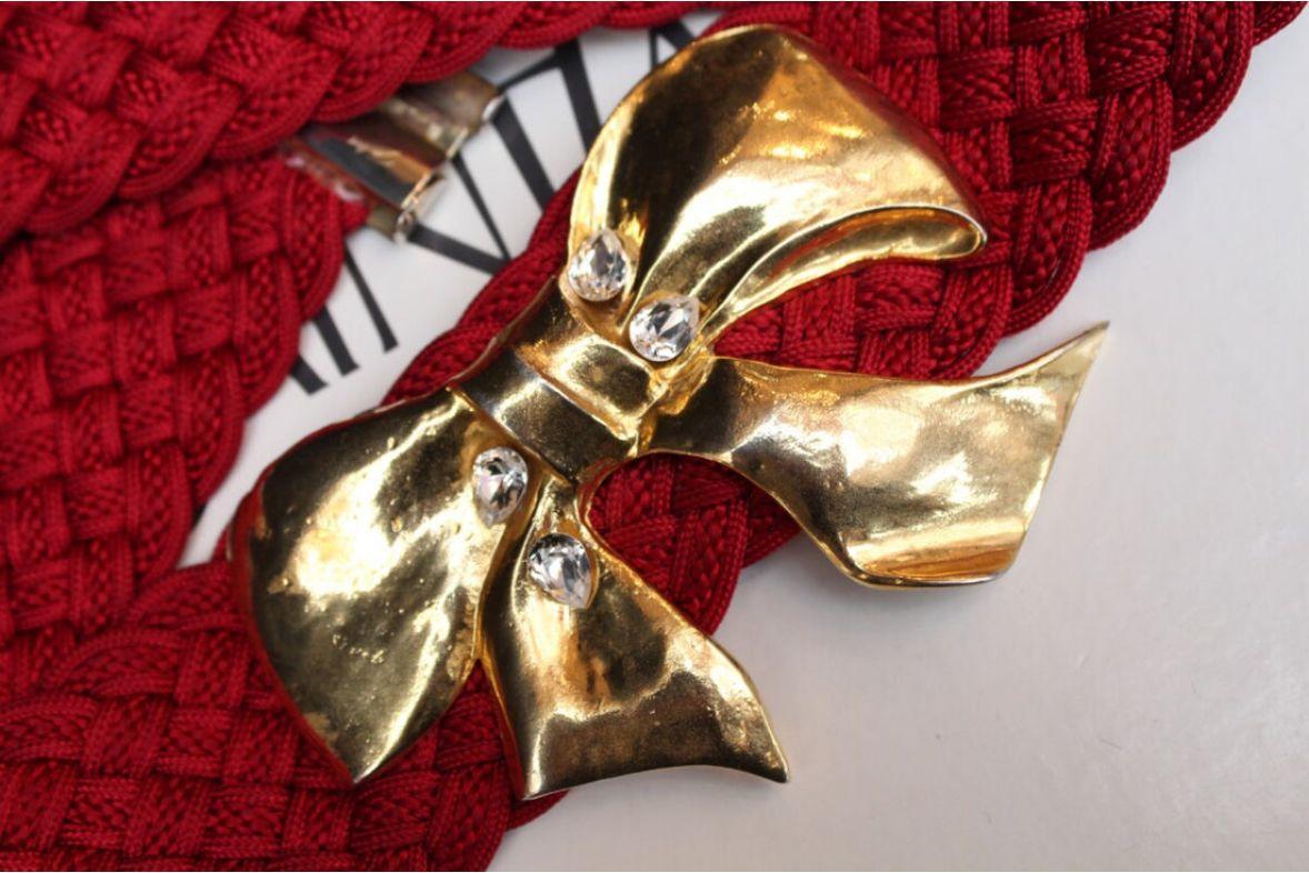 Yves Saint Laurent (Made in France) Gürtel aus rotem Passepartout, verziert mit einer Schleife aus vergoldetem Metall und Strasssteinen. 

Zusätzliche Informationen: 
Abmessungen: Länge: 78 cm (30,7 in) x Höhe: 6,7 cm (2,63 in)
Zustand: Guter