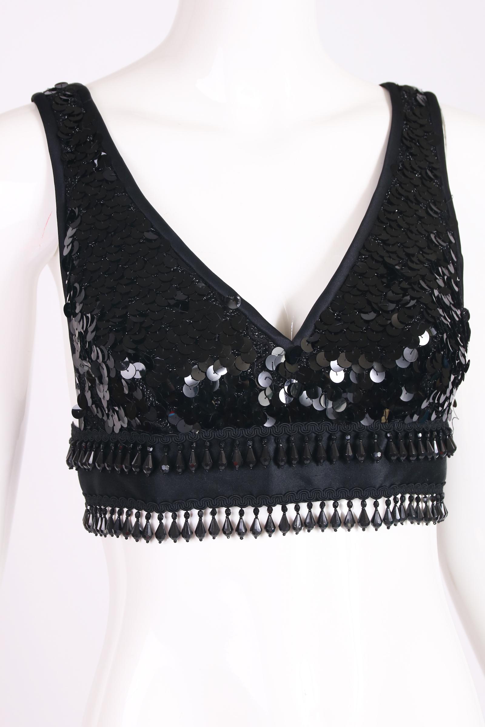 Yves Saint Laurent black silk bralette with sequins, silk cord trim, black and silver metallic background material and faceted hanging beads. No size tag - please consult measurements. In excellent condition - missing one hanging bead at the back