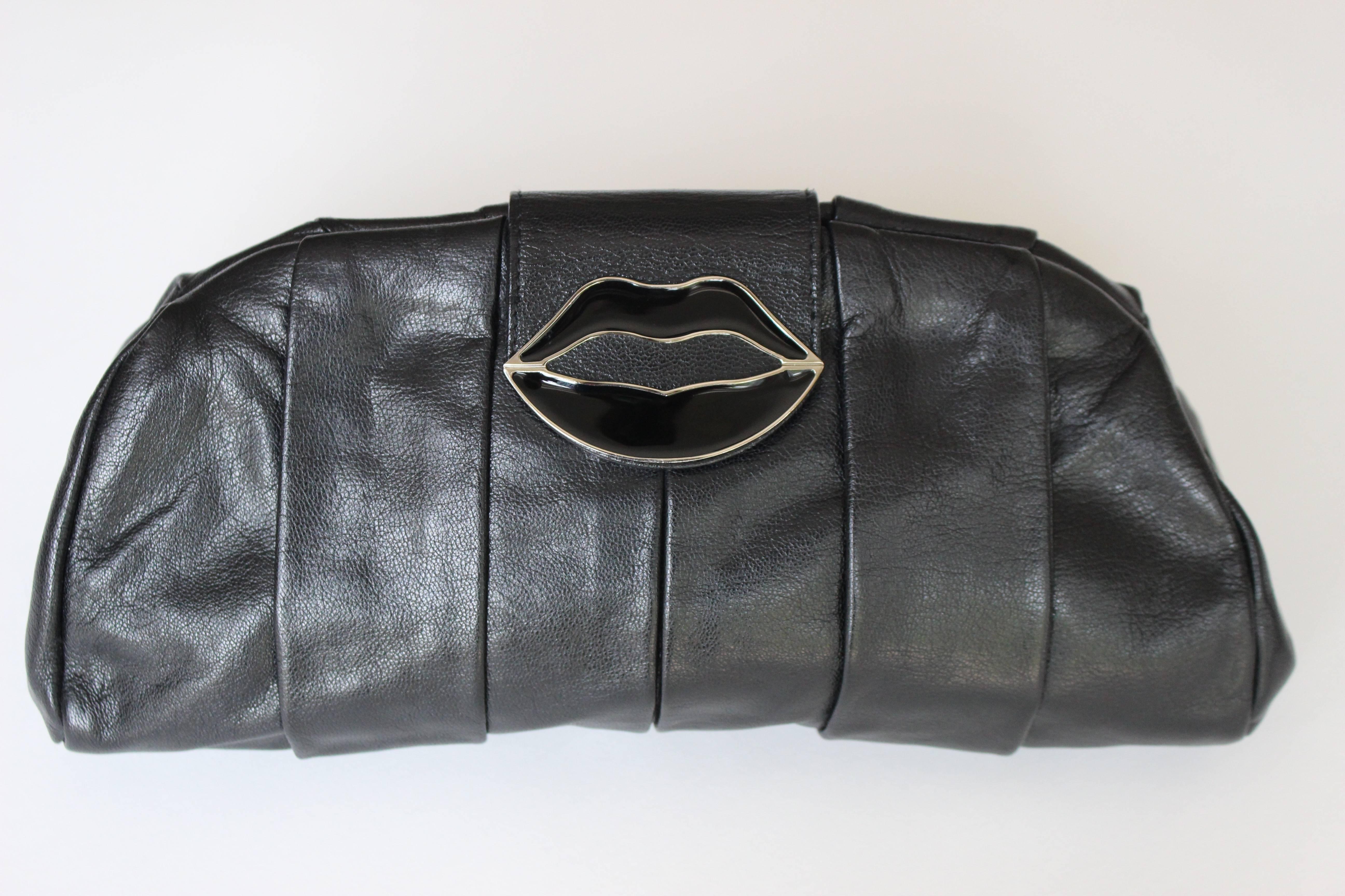 From The Spring 2003 Yves Saint Laurent Collection By Tom Ford Comes This Highly Collectable Black Leather Pleated  Clutch Bag With black and silver kissing  Enamel Lips Magnetic Clasp Closure.
The silver ring detail at the back is to hold the bag.