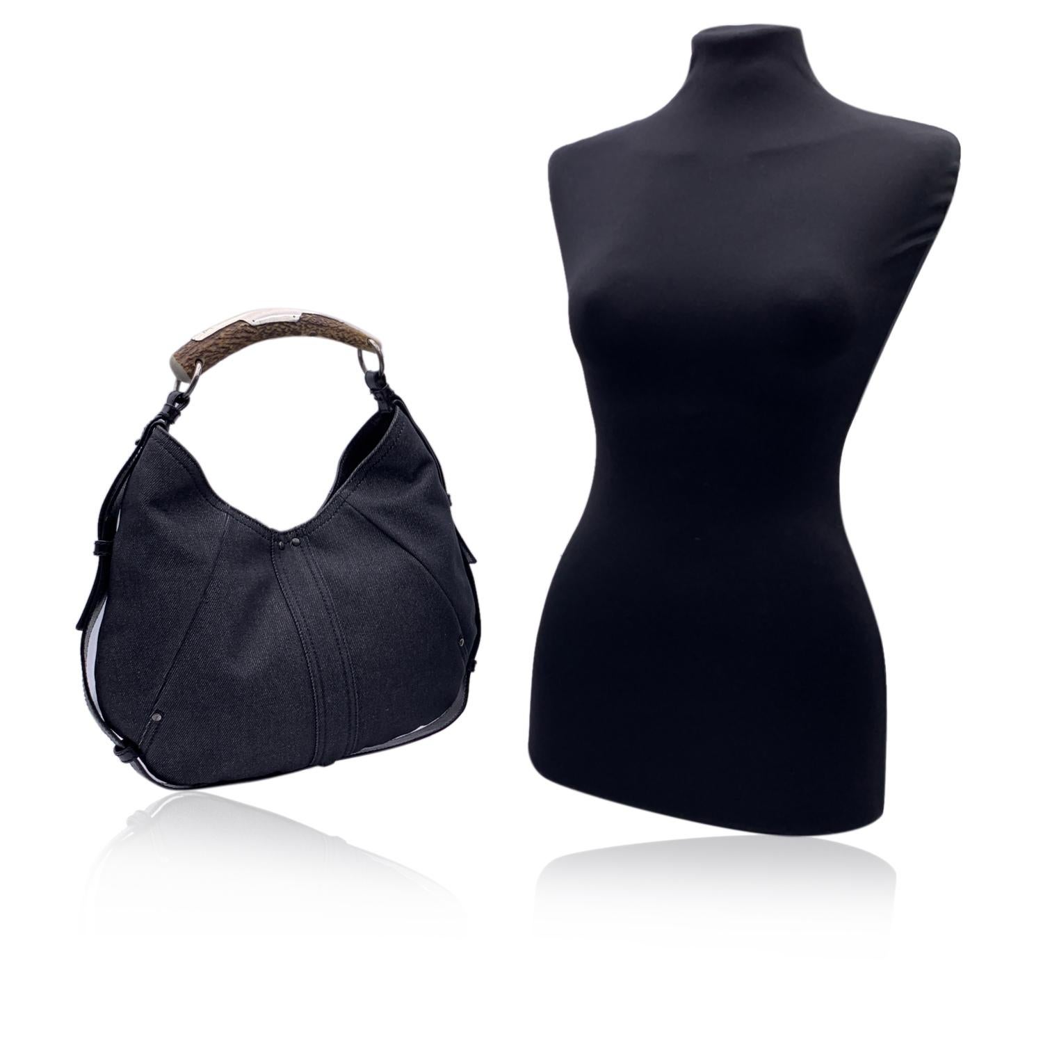 Borsa Mombasa di Yves Saint Laurent in tela denim nera. Disegnata nel 2001 da Tom Ford per Yves Saint Laurent, la MOMBASA Bag è stata citata dal Wall Street Journal come una 