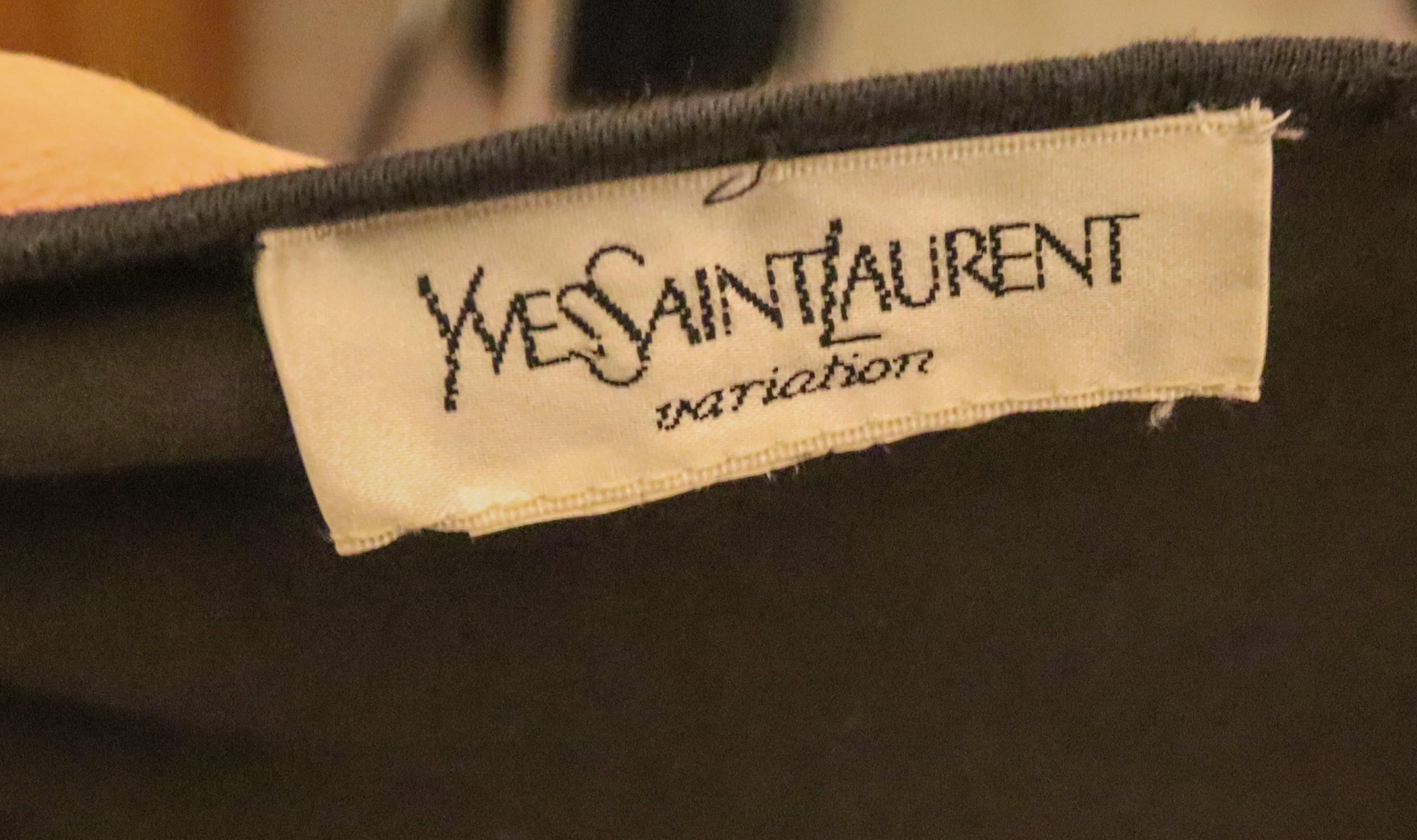 An easy to wear and interesting dress by Yves Saint Laurent, variation line. In a black jersey like fabric, the dress has a v neckline, and cutaway detail on the sleaves and hem. 
Measurements: Bust up to 38', length 48''
