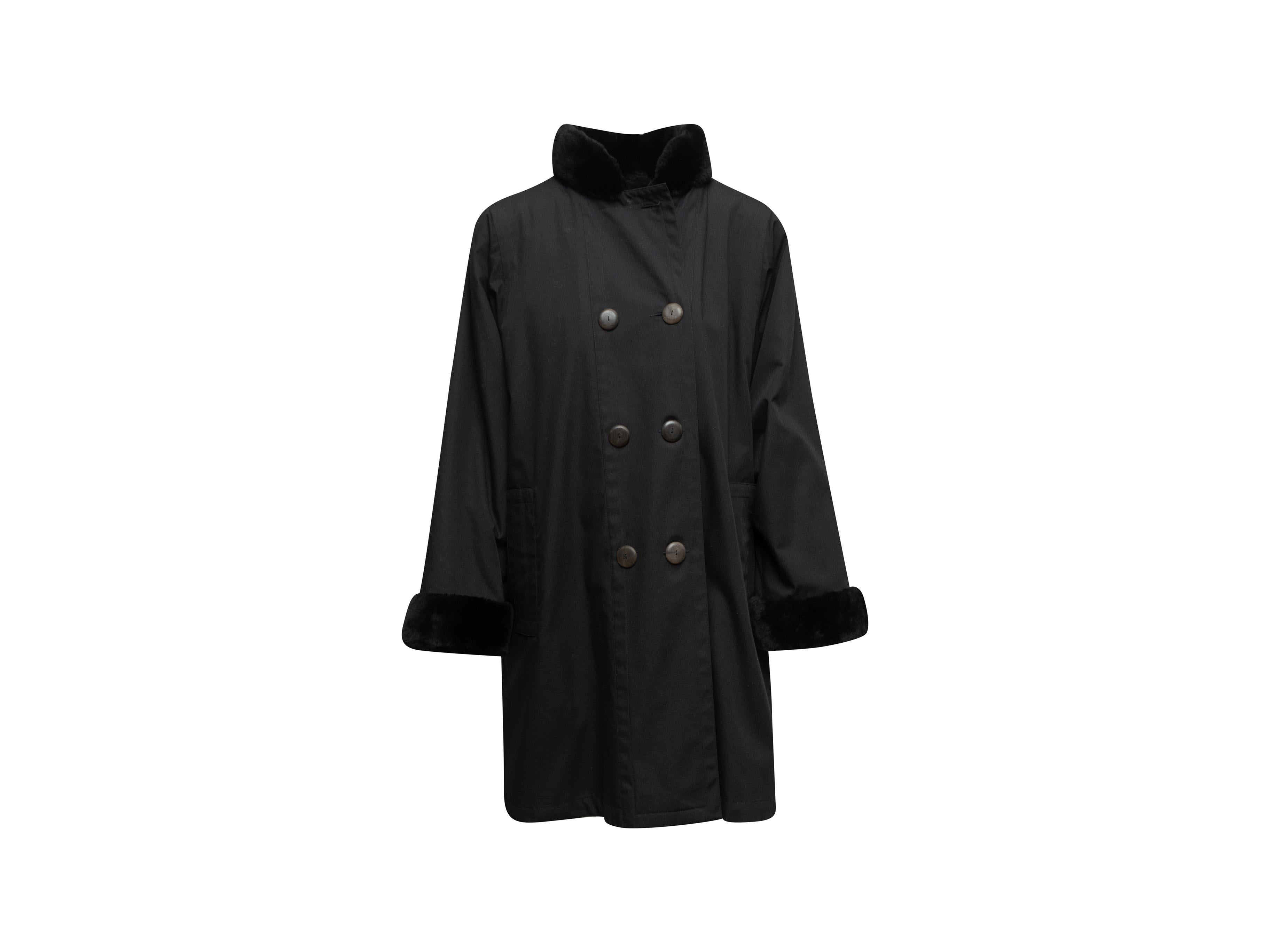 Product details: Vintage black mid-length double-breasted coat by Yves Saint Laurent. Beaver lamb fur trim throughout. Stand collar. Dual hip pockets. Button closures at front. Designer size 40. 34