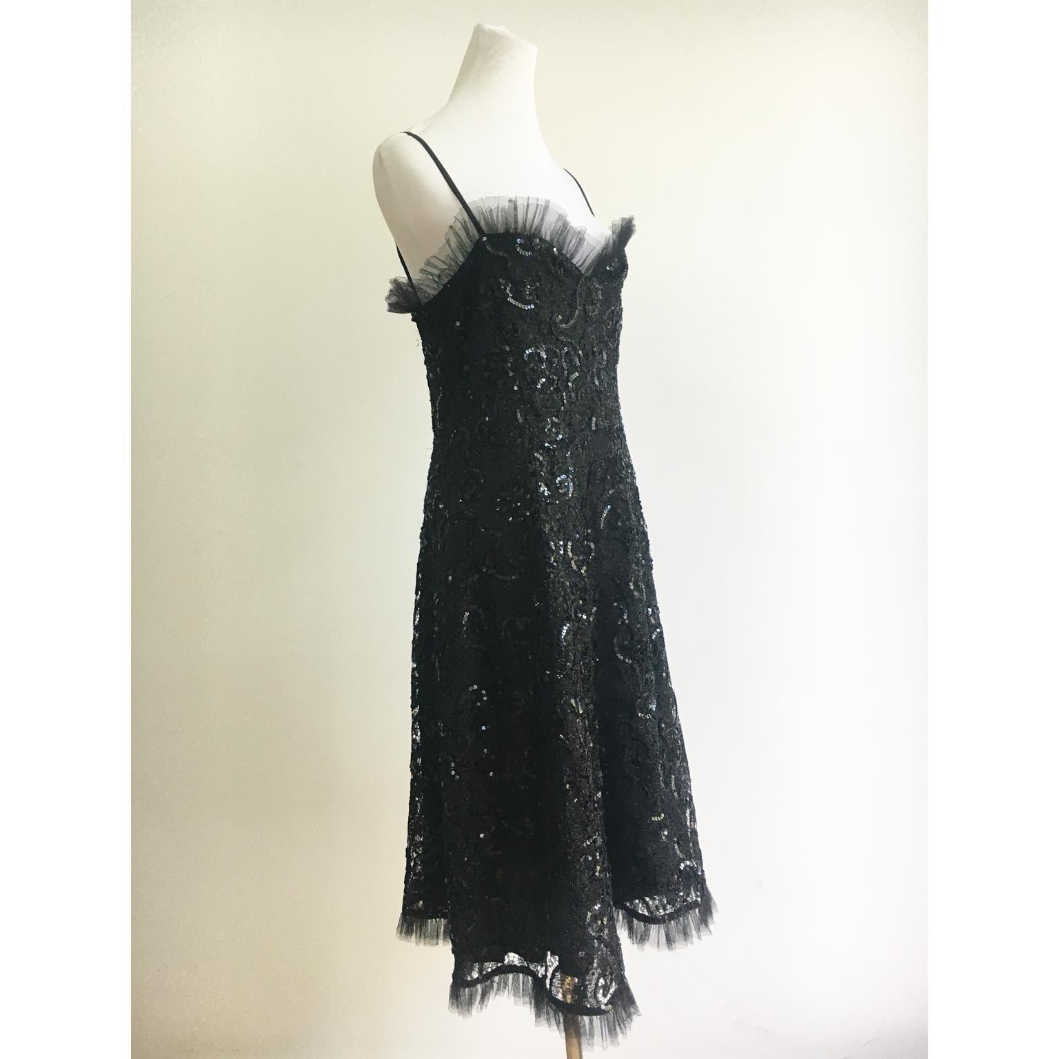 Yves Saint Laurent black lace sequin dress from AW 1987.
The dress has beautiful cut and the pattern in the lace is detailed with curving rows of glossy black sequins. 
The bodice and hem are finished with a silk tulle ruffle. 
Fully lined in a