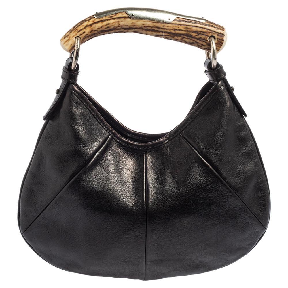 It is indeed rare for one to chance upon a hobo as gorgeous as this one from Yves Saint Laurent. It comes beautifully crafted from leather and designed in a lovely black hue as well as a horn handle detailed with silver-tone hardware. The bag also