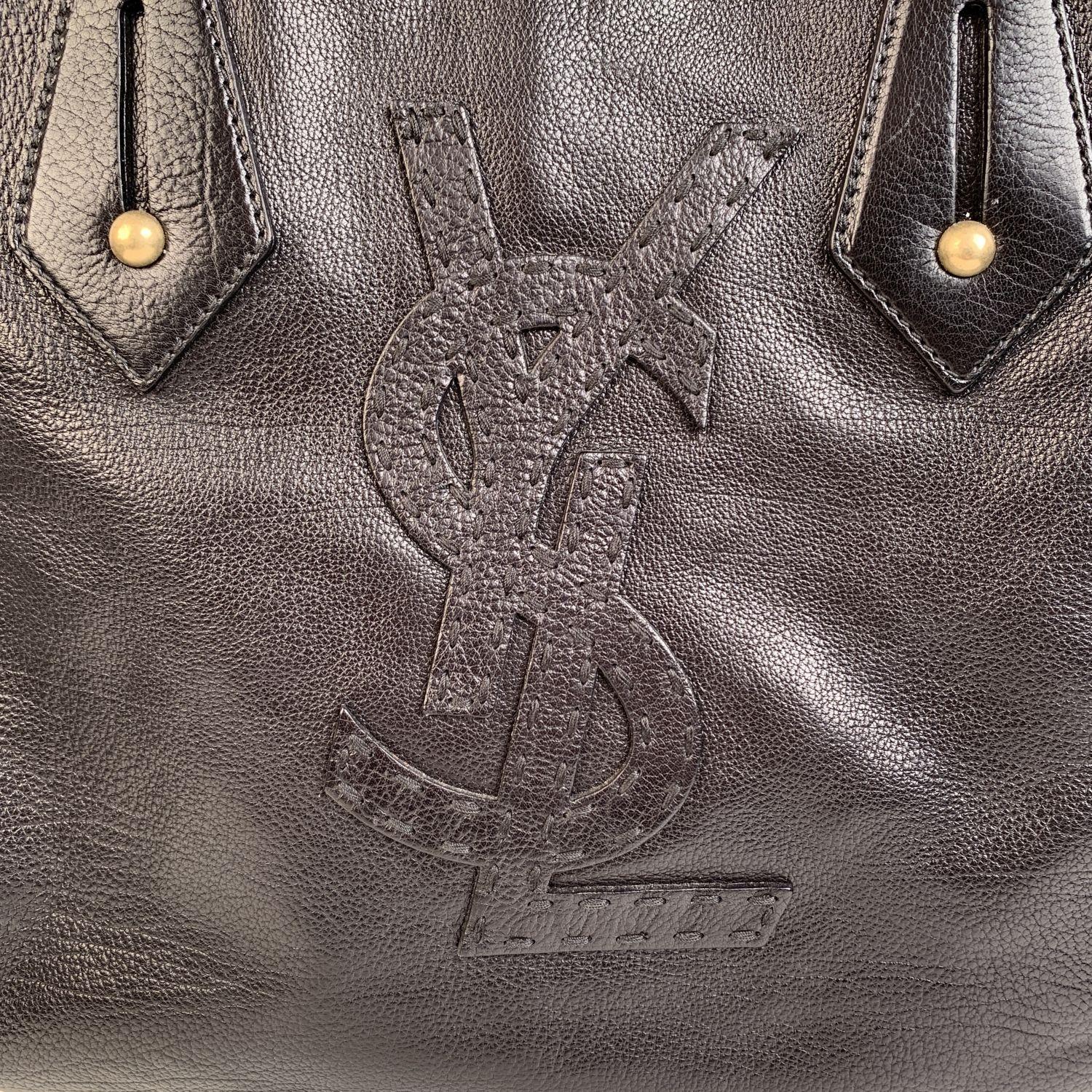 This bag will come with a Certificate of Authenticity provided by Entrupy, at no further cost.

YVES SAINT LAURENT black leather tote bag, with big YSL logo on the front. Magnetic button closure on top. Double leather handles. Black satin lining. 1