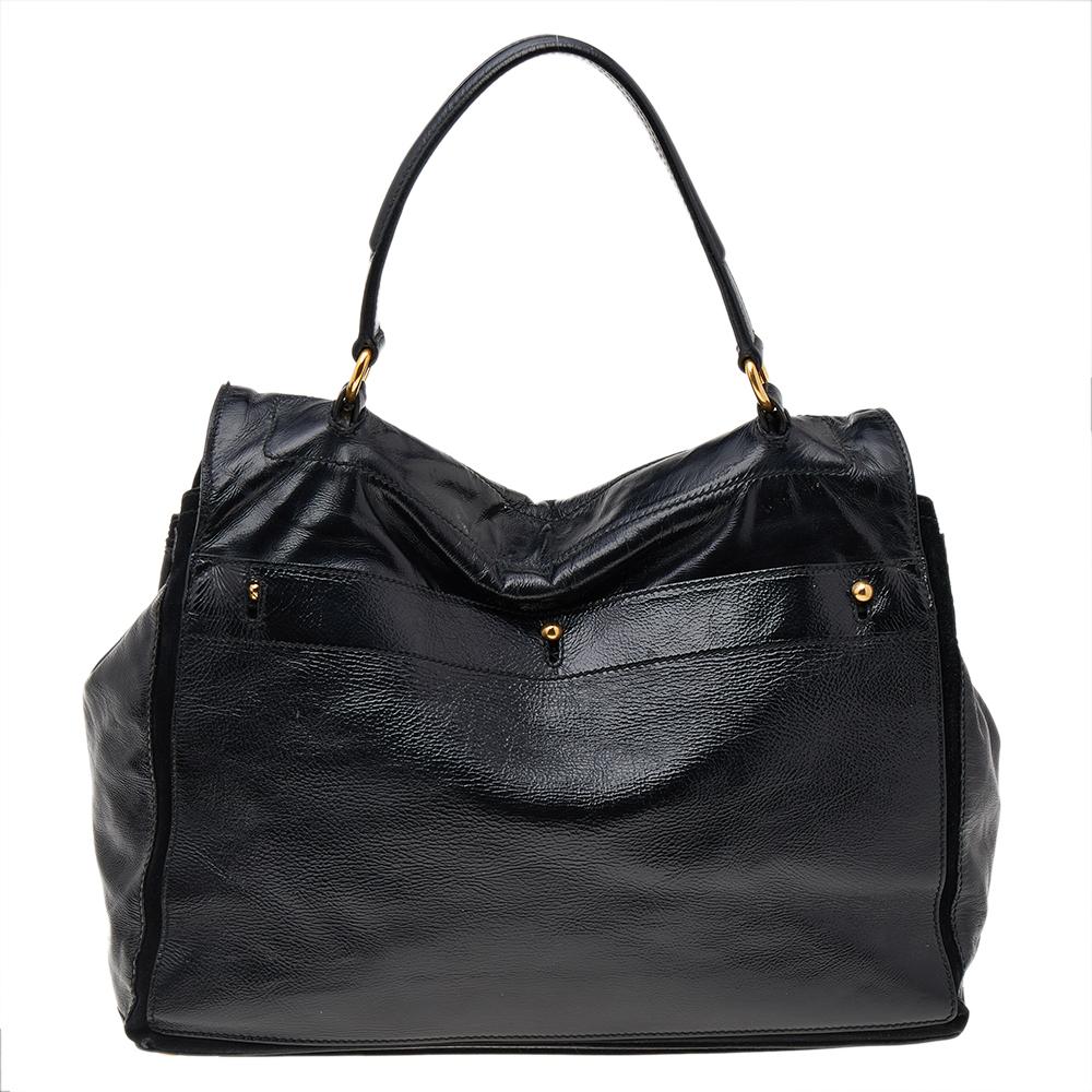 Make everyone nod in approval when you step out swaying this Yves Saint Laurent bag. It has been crafted from black patent leather & suede and held by a top handle. The bag has a flap that leads to a spacious suede interior and it is perfectly made