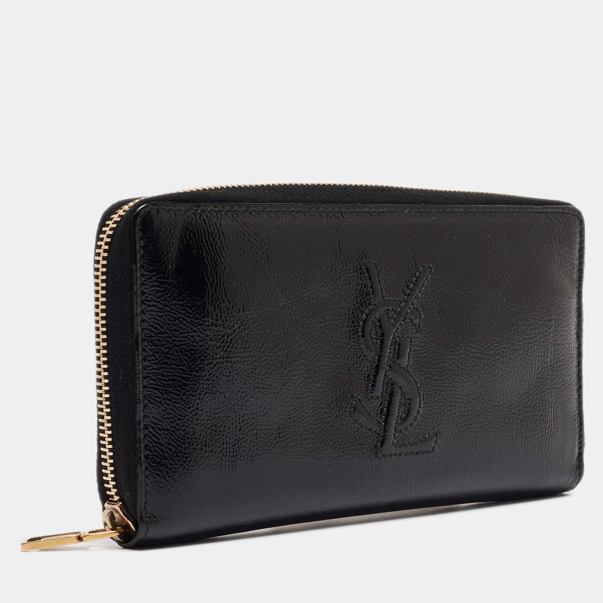 Un portefeuille ne doit pas seulement être beau mais aussi fonctionnel, comme ce joli portefeuille Belle De Jour d'Yves Saint Laurent. Fabrice en cuir verni noir, cette création présente un intérieur en tissu de cuir et des ferrures dorées. Ce