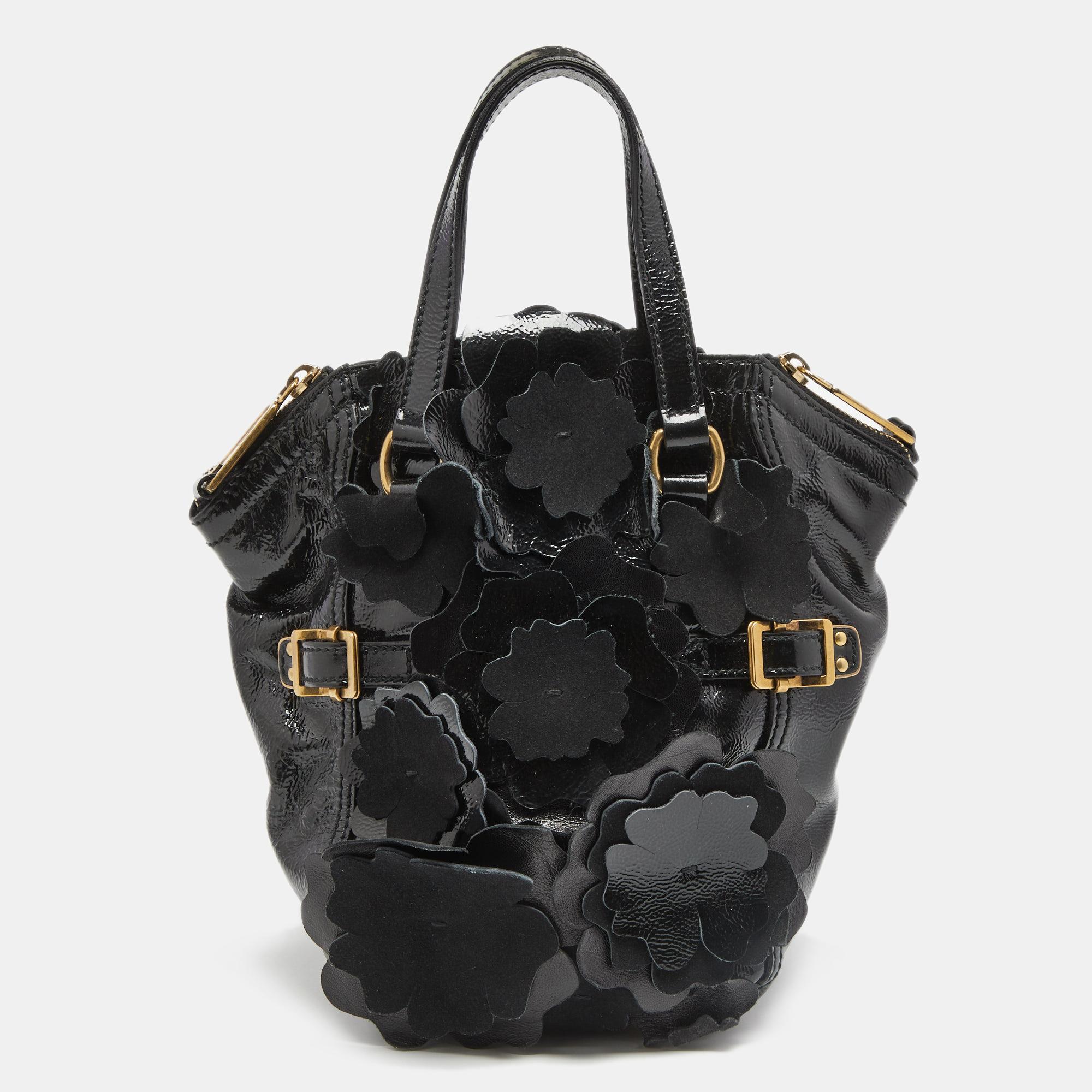 Every woman needs a bag that is pretty and functional, just like this Downtown tote from Yves Saint Laurent. Crafted with precision using patent leather, the bag has been styled with cute floral appliques and buckles. It also features two handles
