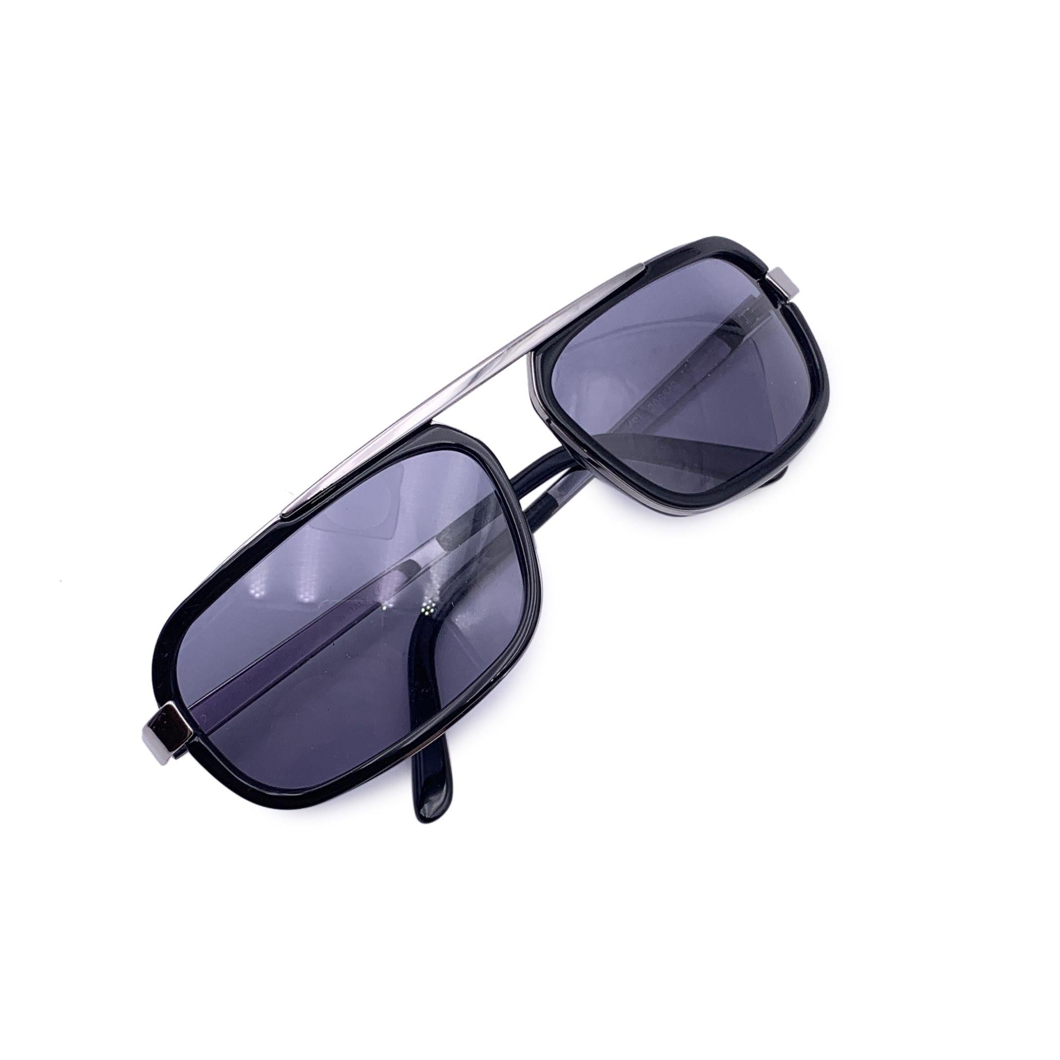 Transpórtate a una época más fría y brillante con estas gafas de sol vintage Yves Saint Laurent, Model 2065/S: un elegante trozo del lujo de principios del año 2000. Diseñada en Italia, esta pieza sobresaliente combina una atrevida montura de