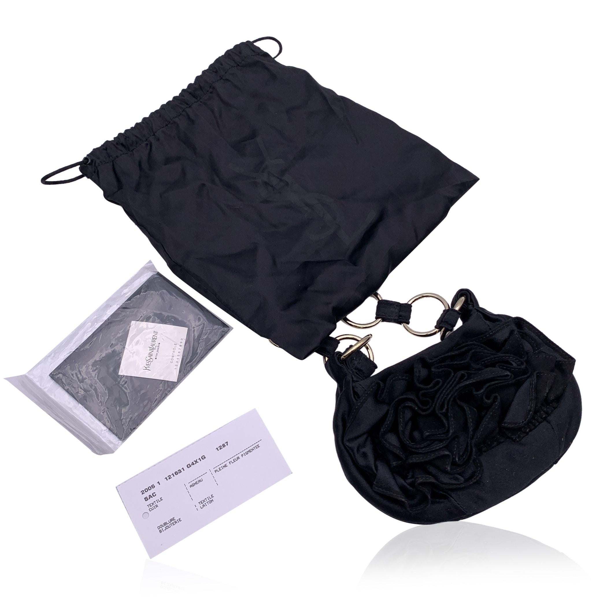 Yves Saint Laurent Black ruffle mini bag, crafted in black satin. Silver metal hardware. Magnetic button closure on top. Black lining. 1 side open pocket 'YVES SAINT LAURENT - Rive Gauche' tag inside (with 'Made in Italy' and serial number embossed