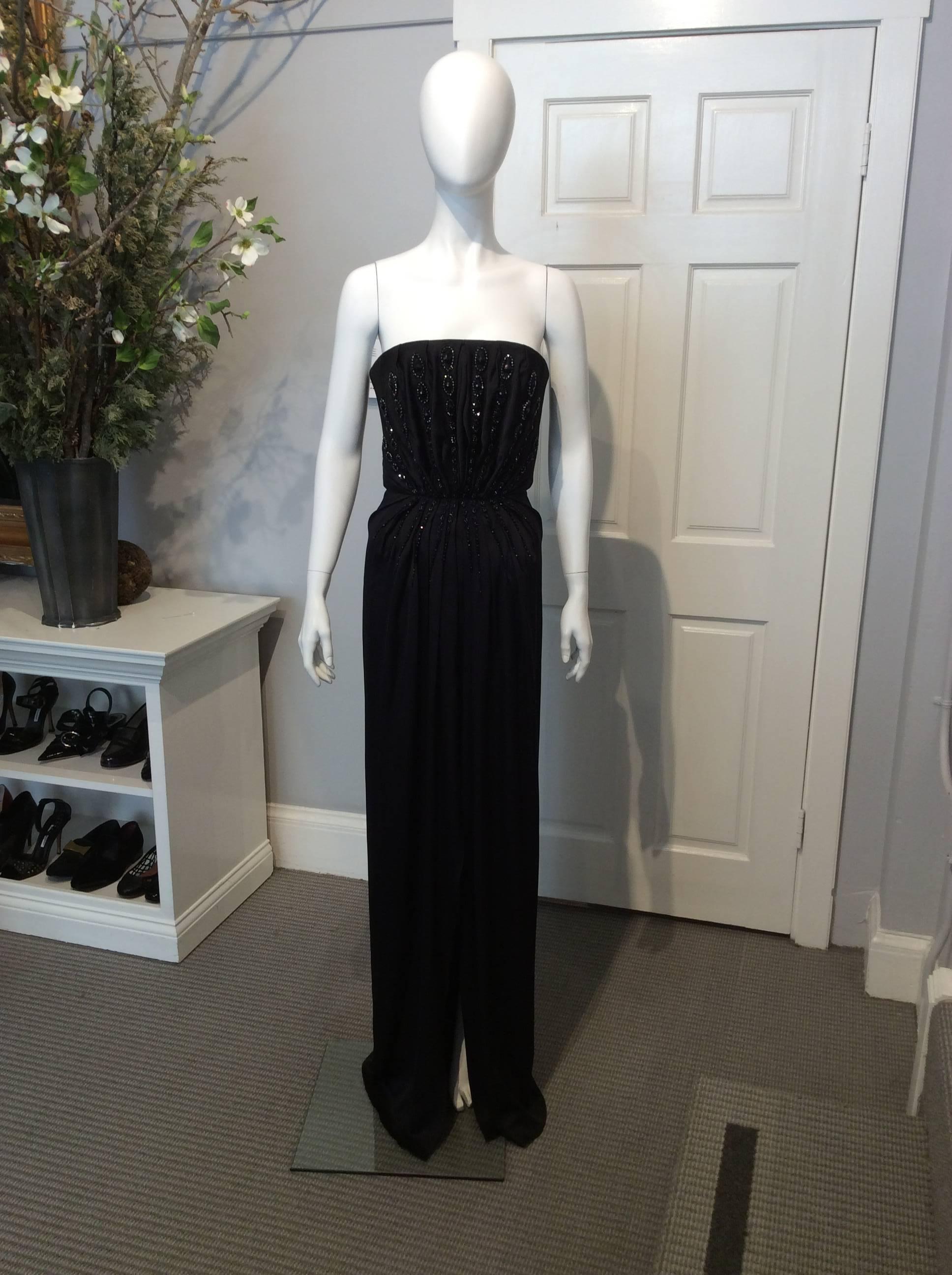 Yves Saint Laurent Edition Soir Black Silk Beaded strapless evening gown with front slit. Zip closure with built-in corset. Black and hematite beaded embellishments fan out from bust to waist and hips. 

Sizing: Us6 and Fr38

Fabric content: 100%