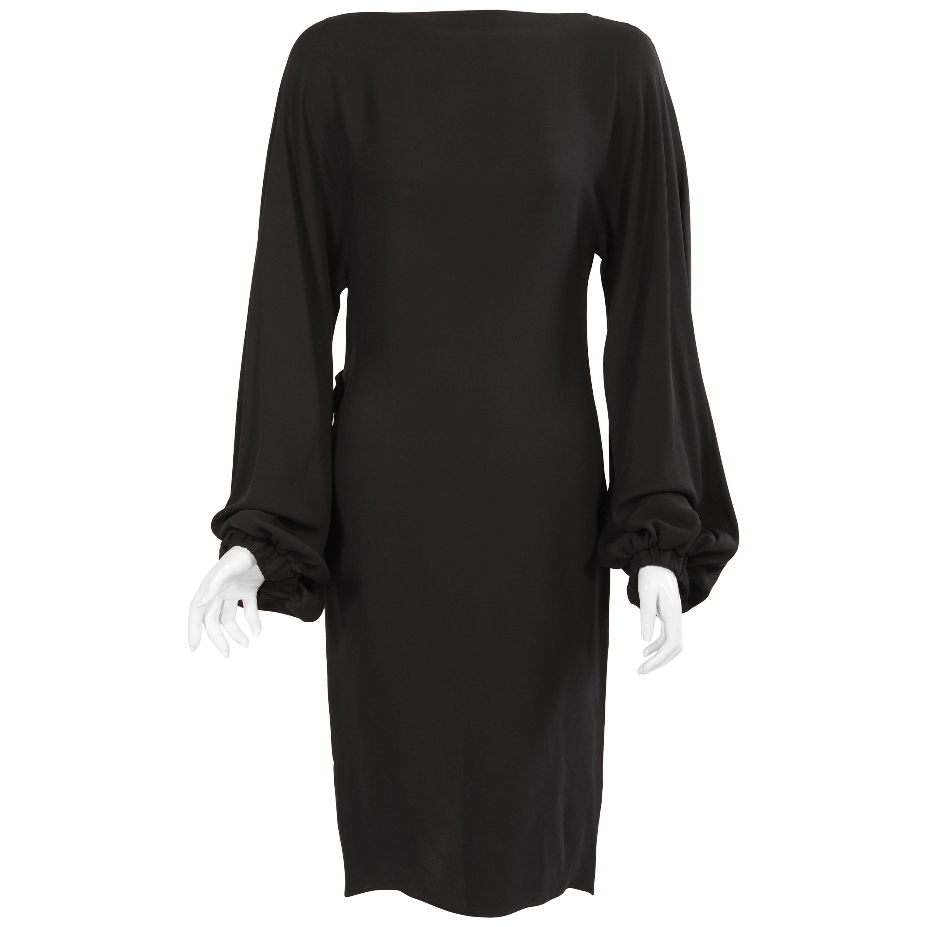 Classic and elegant at first glance, this dress is cut to there in the back. The simple bateau neckline and long sleeves gathered at the wrist are the perfect foil for the drama of the wrap back of this dress.  It goes left to right with a hidden