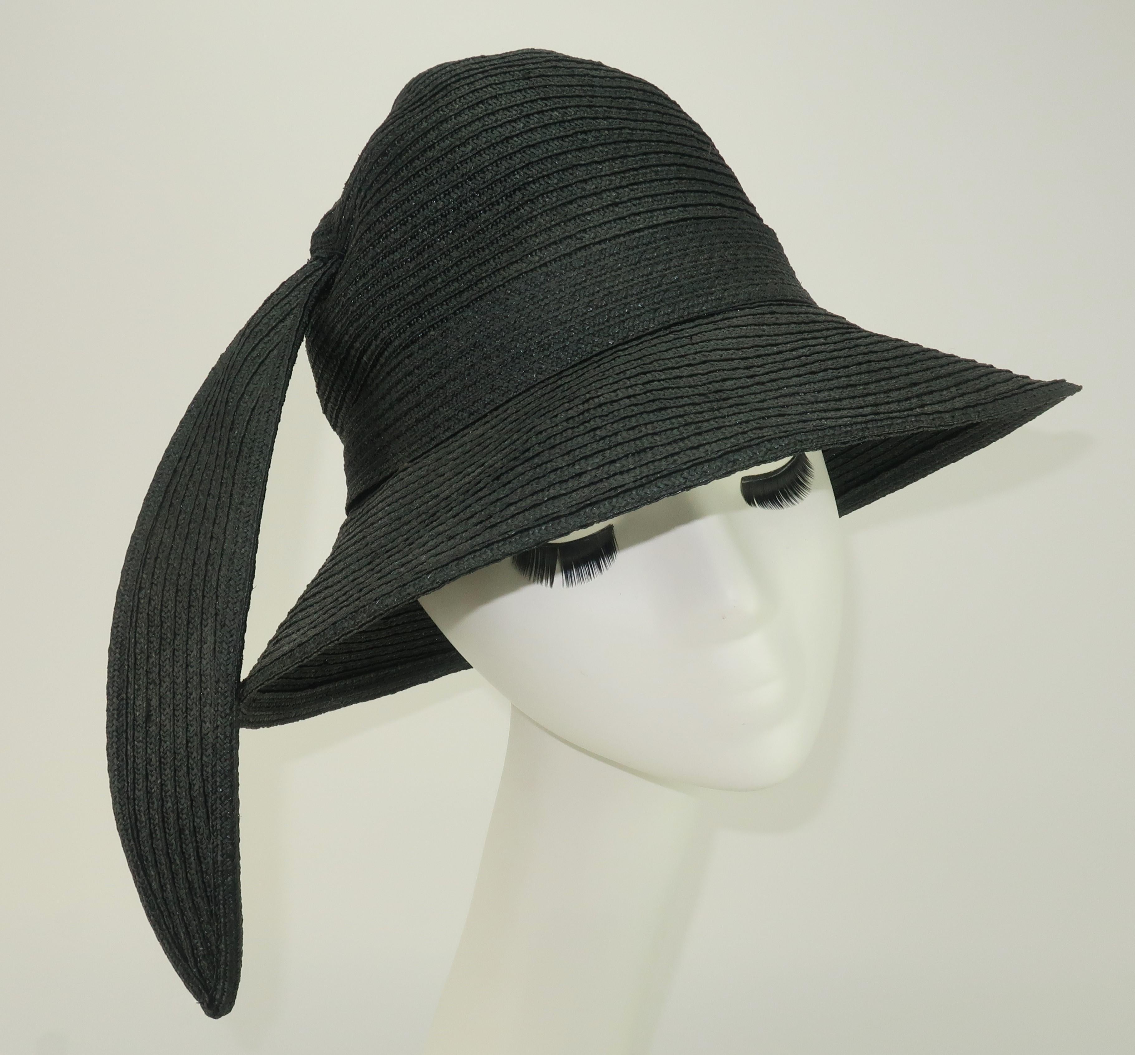 1970's Yves Saint Laurent black straw hat in a bucket shape with a black straw embellishment reminiscent of a feather making this topper a true 'feather in your cap'!  The inside rim is lined with YSL's iconic aqua blue grosgrain ribbon and the hat