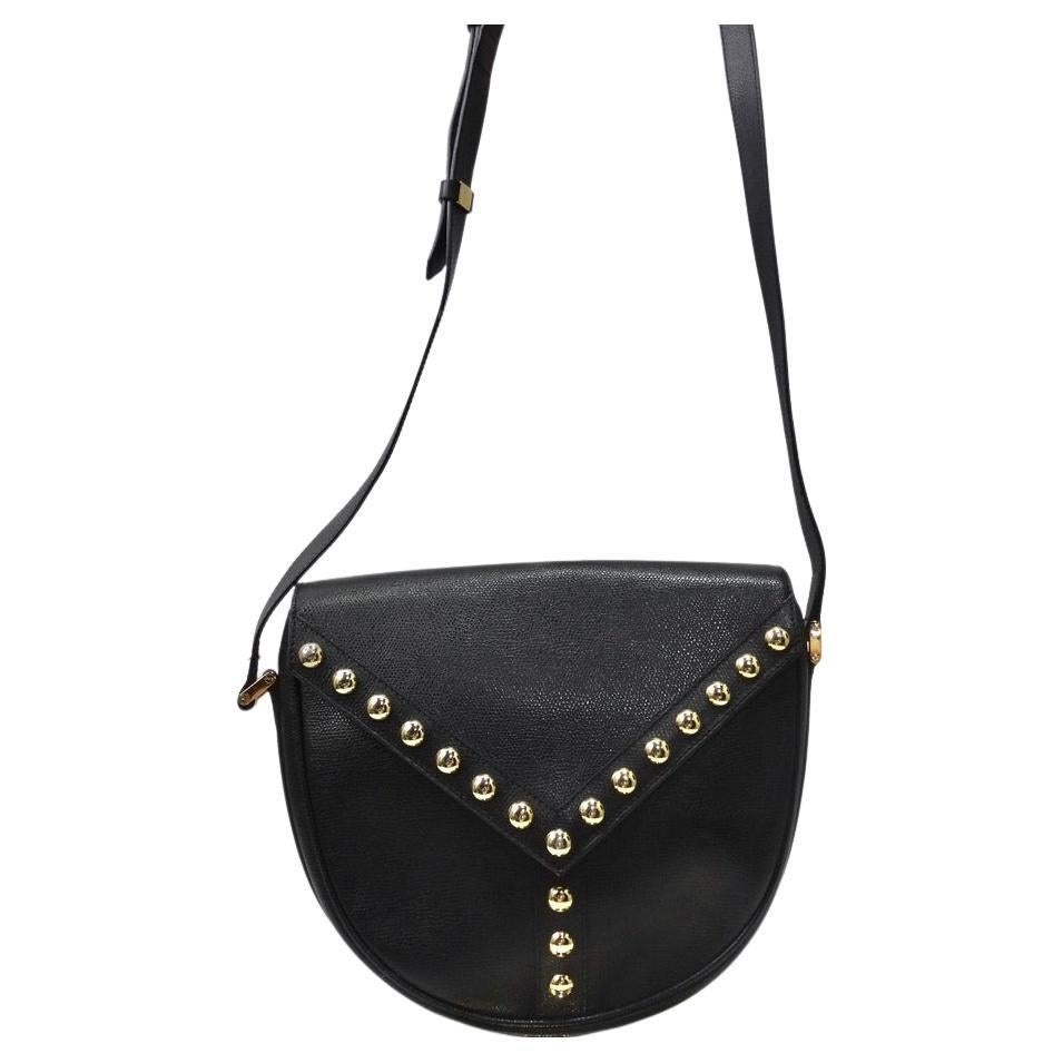 Gorgeous vintage Yves Saint Laurent black bag with gold hardware. Super classic crossbody style with an adjustable strap allows for versatility with wear. The front flap is lined with gold studs as well as the center of the bottom which takes it to
