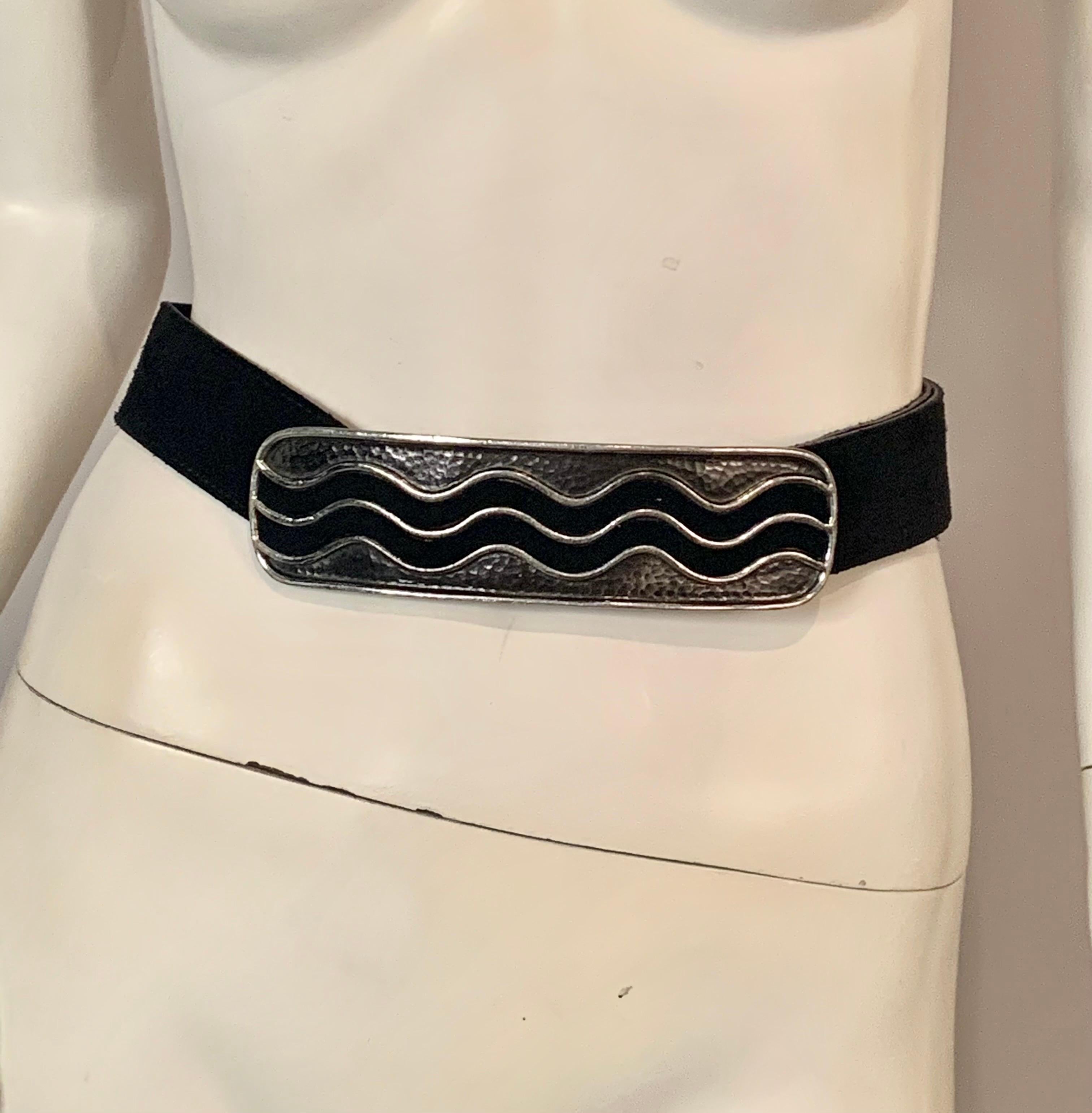 A chic black belt from Yves Saint Laurent features a long horizontal buckle with hammered metal and 