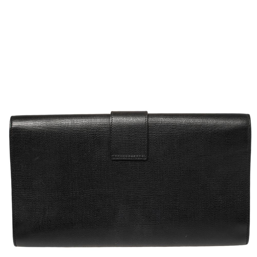This Y-Ligne clutch from Yves Saint Laurent is one creation a fashionista like you must own. It has been wonderfully crafted from textured leather and it flaunts a classy black hue. It comes equipped with a front flap that opens to reveal a satin