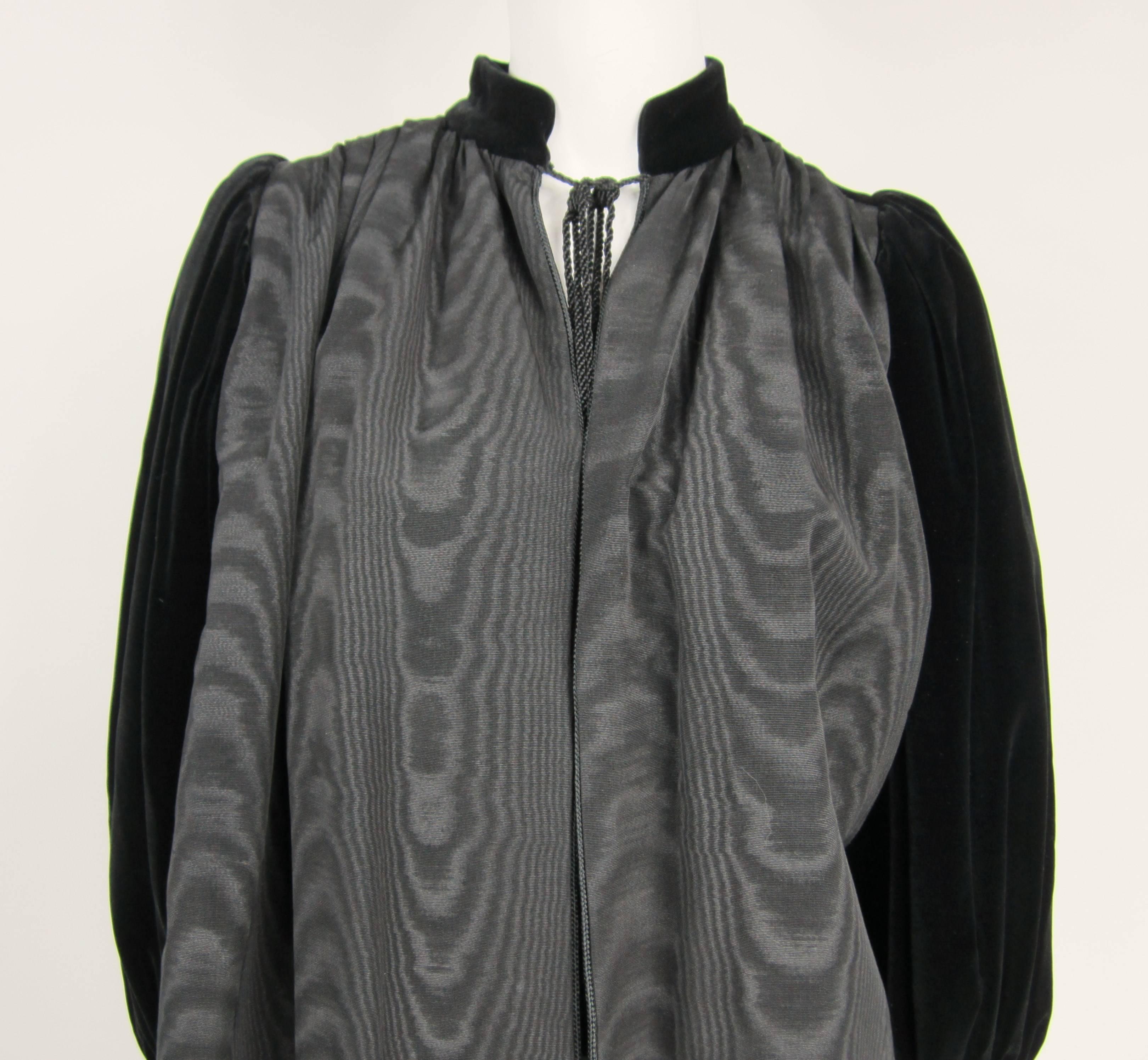 This is a stunning Yves Saint Laurent YSL black on black Velvet sleeved Jacket. Mandarin Collar with tassel cord closure. Balloon sleeves.. Banded cuff 2 slit hidden pockets. Labeled a Size 34 Measuring approximate up to a 42 chest -- Open waist --